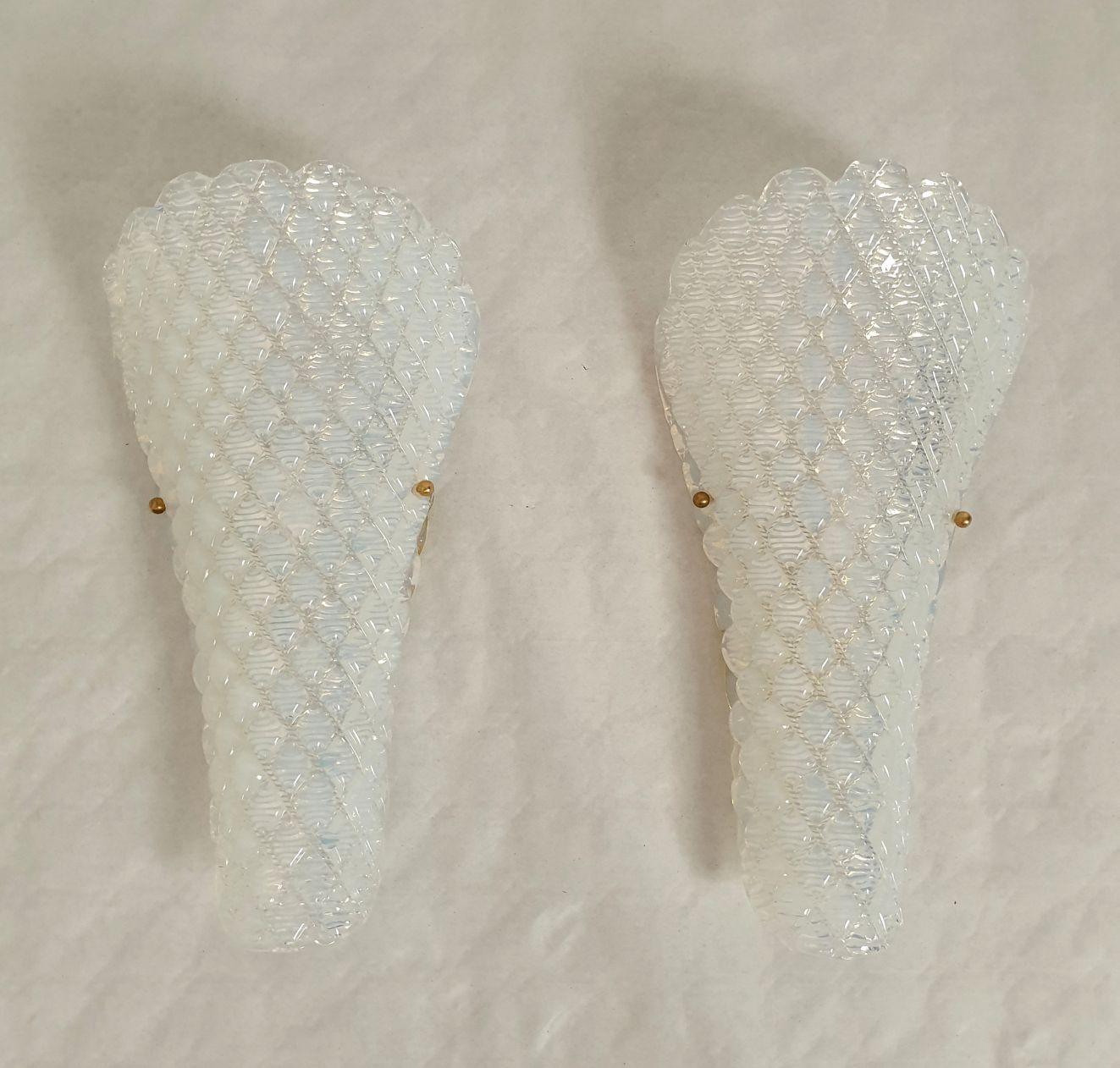 Pair of opaline Murano glass sconces, Mid Century Modern, attributed to Mazzega, Italy 1970s.
Set of three pairs, or six sconces available. Sold and priced by pair.
The Italian sconces are made of a single thick piece of Murano glass, curved, with a
