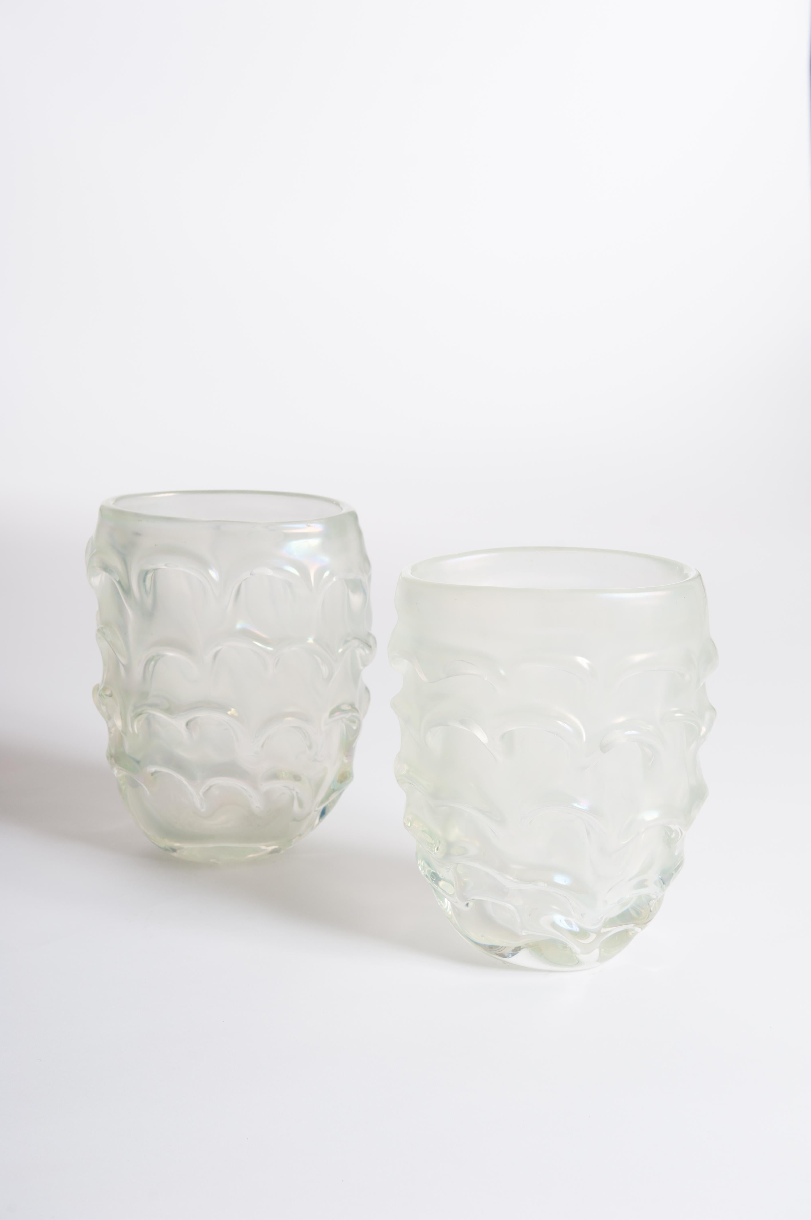 A pair of modern handcrafted Italian Murano glass vases light green-irisdecent colored with surreal impression.
The oval shaped body out of opaline Murano glass shows glass movements outside on the surface and turns the
vase into a sculpture. The