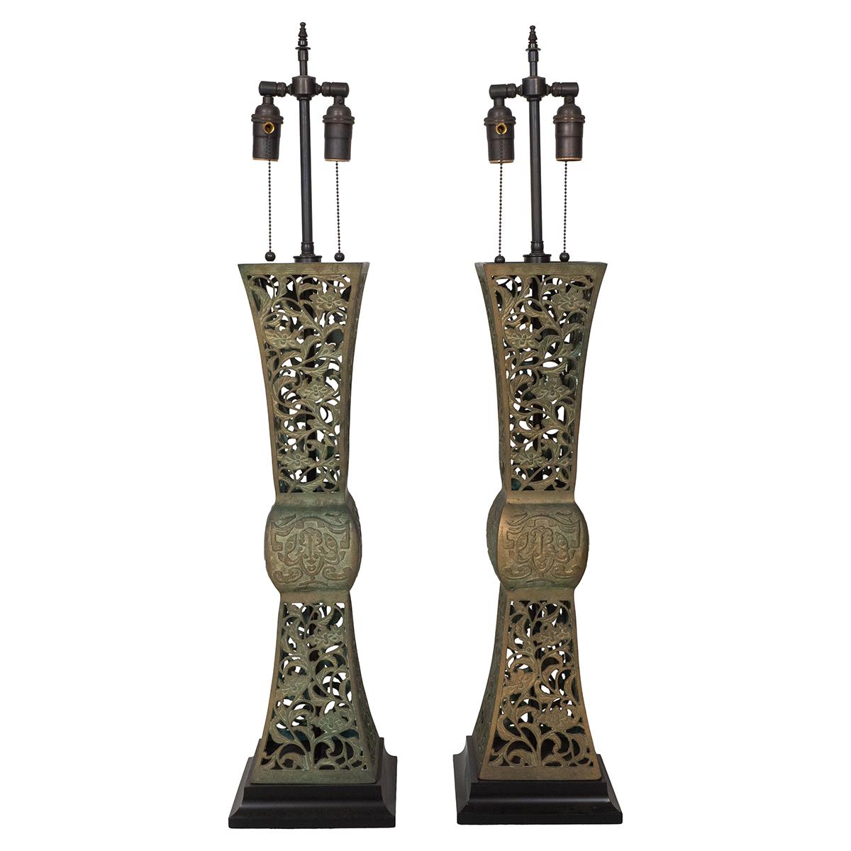 Pair of openwork patinated bronze table lamps on black wood bases.