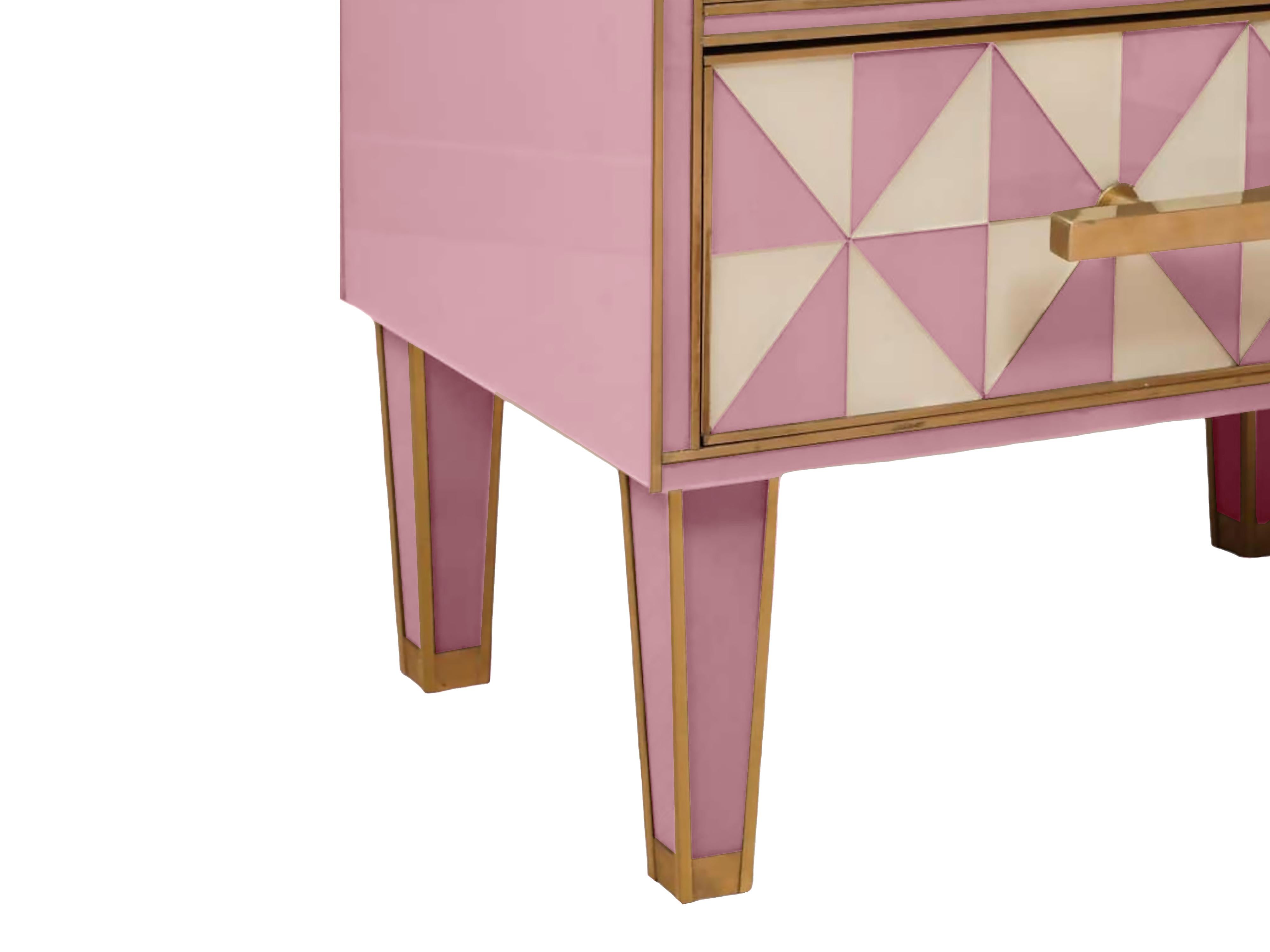 Este par de mesillas de noche italianas presenta un llamativo efecto óptico, mezclando cristal de Murano rosa y blanco con elegantes detalles de latón. 

Inspirada en la década de 1950, cada mesilla de noche cuenta con un marco de madera maciza y