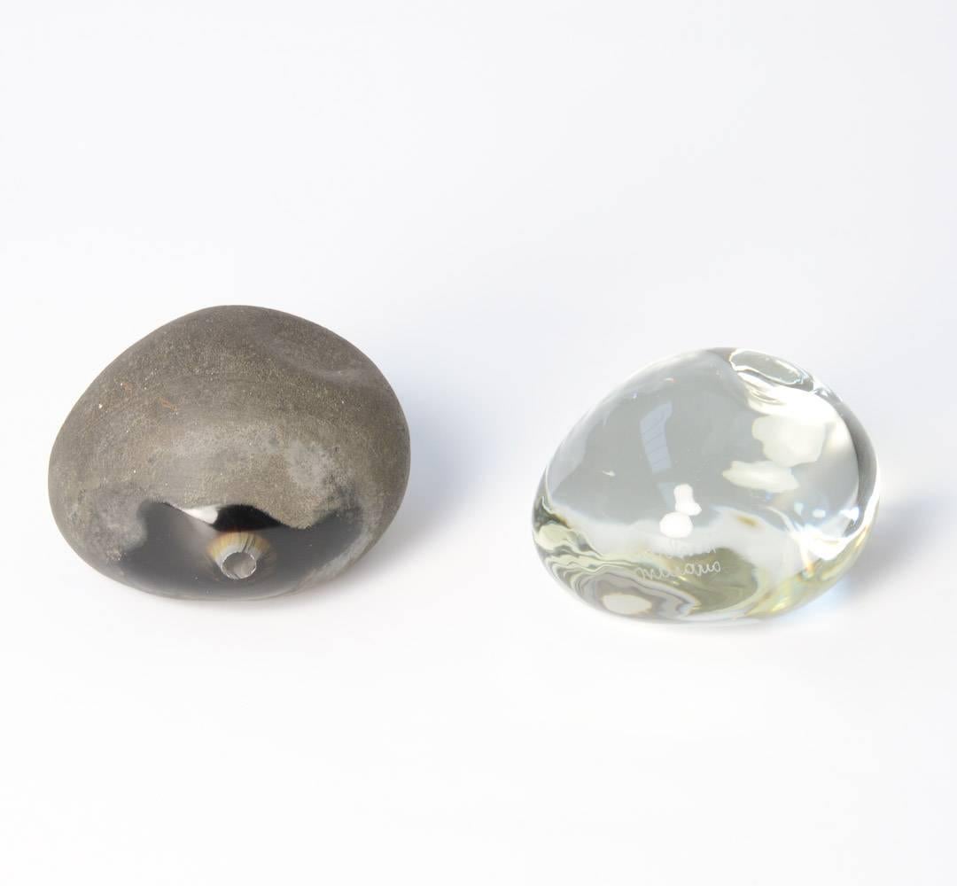 These optical glass stones are created by the Italian glass artist Alfredo Barbini in his workshop in Murano, Venice. They can be dated in the 1950s.
One stone is made of scavo glass, a process of acid washes over the glass has create a matte