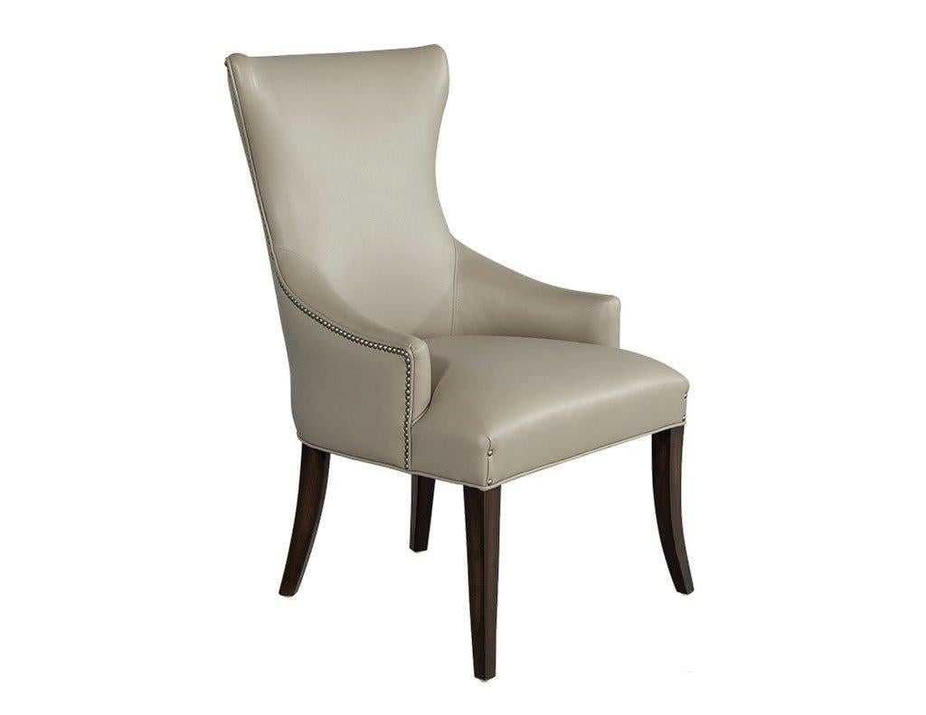 The custom made Opus Arm Chairs by Carrocel are a refreshing style of parsons chair. The modern shape is defined by a low arm and curved silhouette. Upholstered in supple grey leather with aged nickel head-to-head nail trim around the outside back.