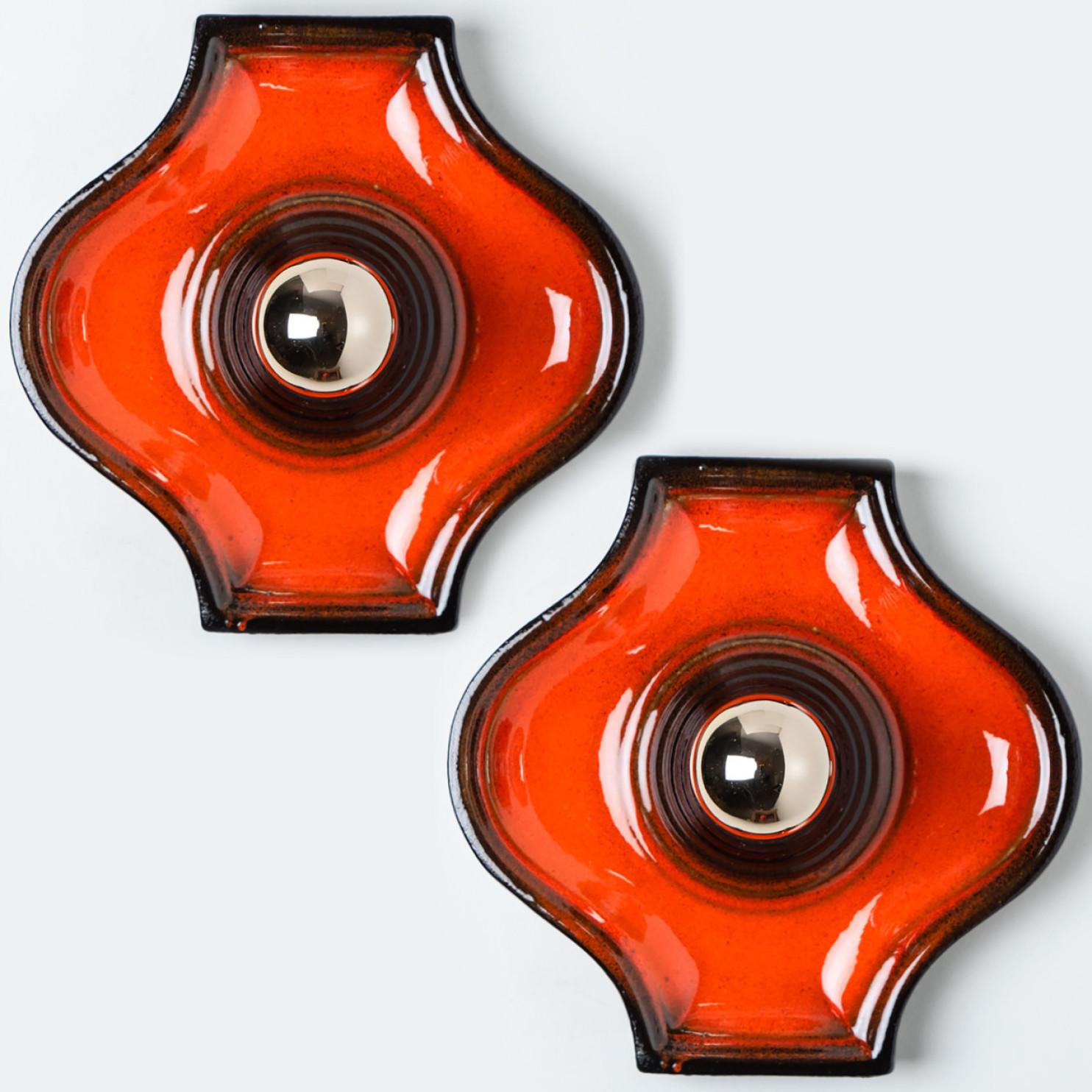 Ceramic wall light with orange glaze. Manufactured in West-Germany in the 1970's.

A typical way to finish ceramic in mid-century West-Germany, Europe.

Please note the price is for the set of 2. Each light requires one E27 light bulb.


