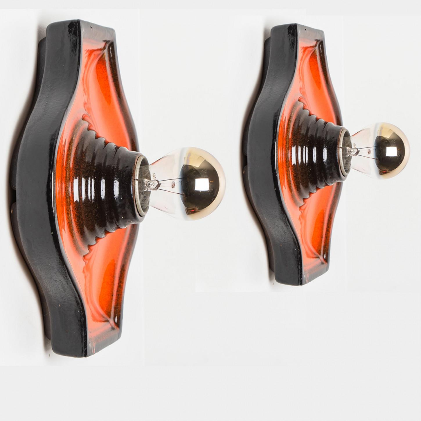 Ceramic wall light with orange glaze. Manufactured in West-Germany in the 1970's.

A typical way to finish ceramic in mid-century West-Germany, Europe.

Please note the price is for the set of 2. Each light requires one E27 light bulb.

