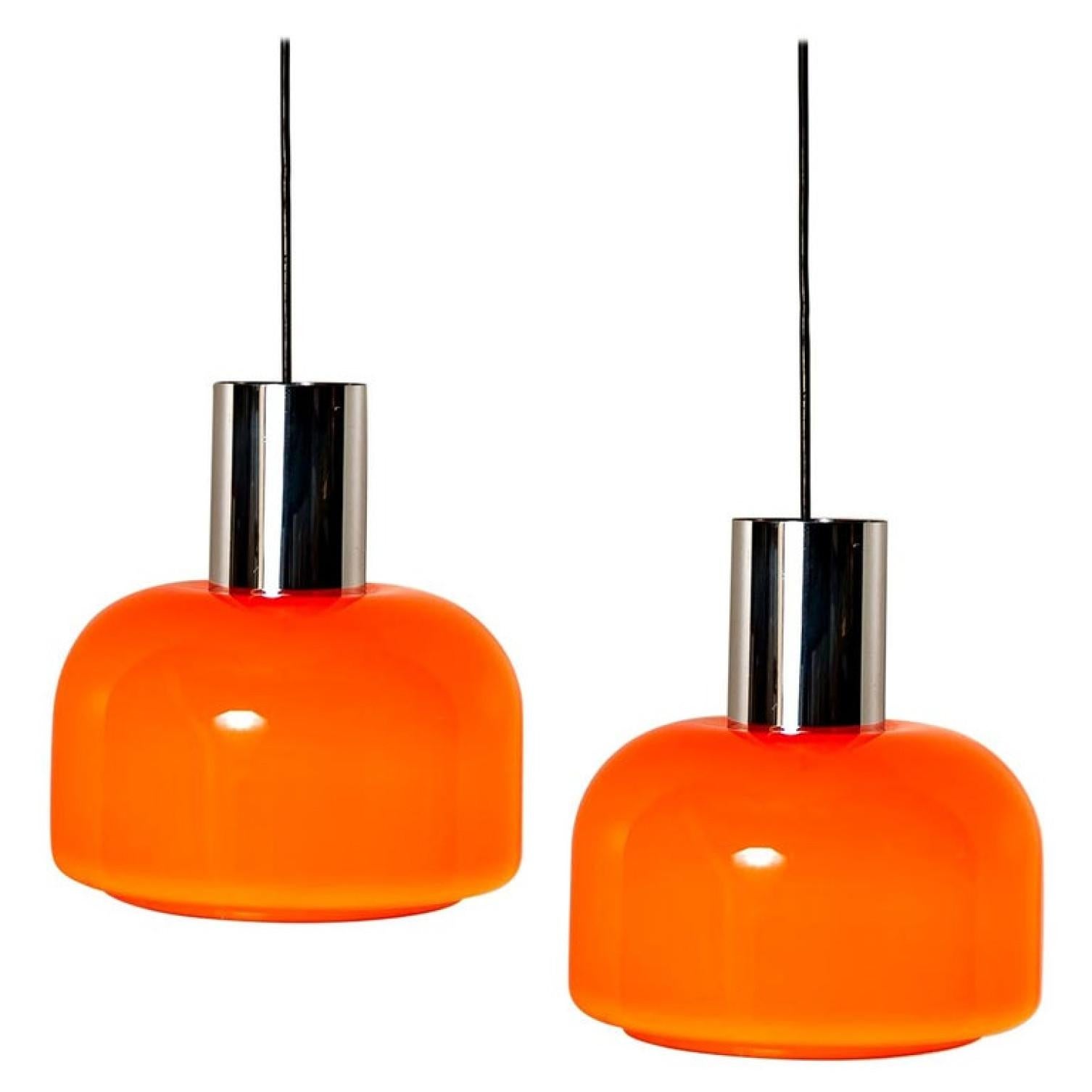 Orange hat etwas, das nach dieser besonderen Ära schreit. Und dieses Paar Peill & Putzler-Pendelleuchten aus den 1970er Jahren ist sehr orange!
Mit Chromdetails, schwarzer Kordel und Baldachin.

Der formschöne, mundgeblasene Lampenschirm besteht aus