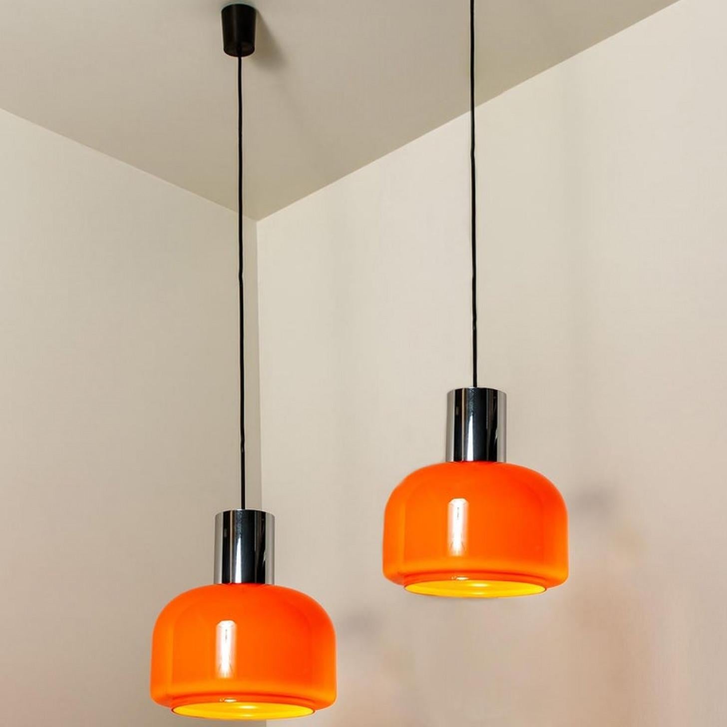 C'è qualcosa nell'arancione che fa pensare a questa particolare epoca. E questa coppia di lampade a sospensione da soffitto Peill & Putzler degli anni '70 è molto arancione!
Con dettagli cromati, cavo e baldacchino neri.

Il grazioso paralume