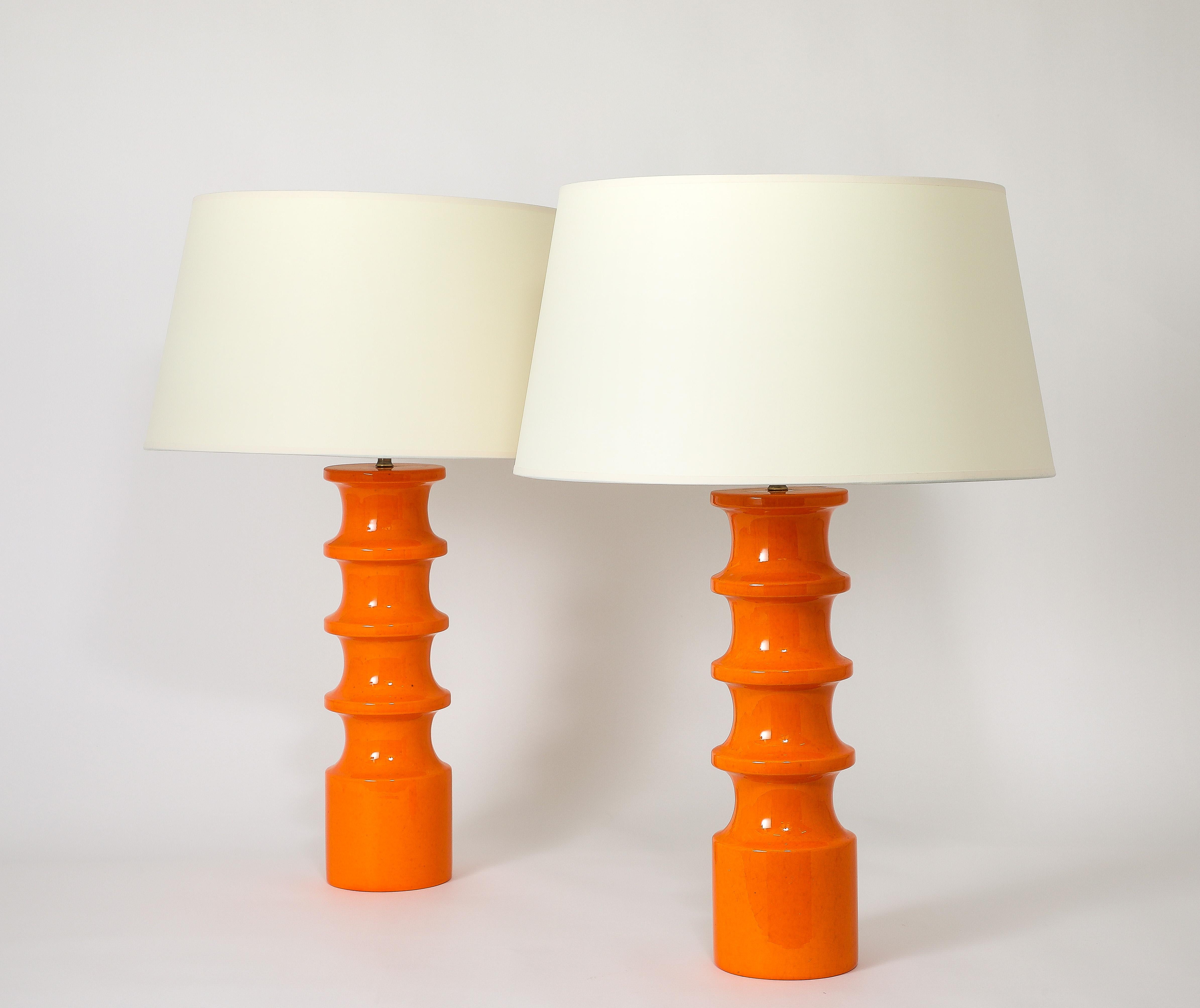 Large ceramic lamps with an orange crackled finish.