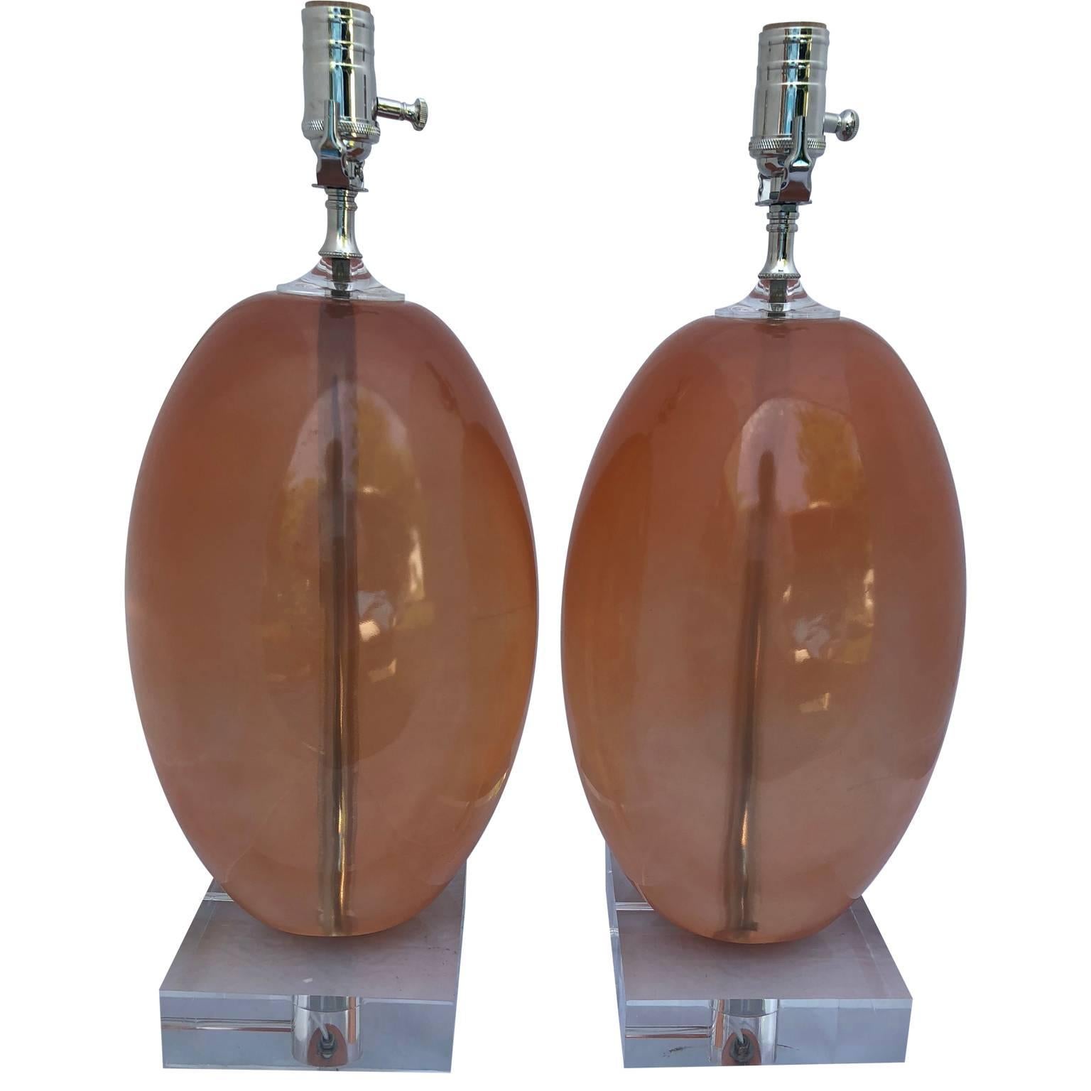 Paar orangefarbene ellipsenförmige Harz-Tischlampen auf dickem Lucite-Sockel (amerikanisch)