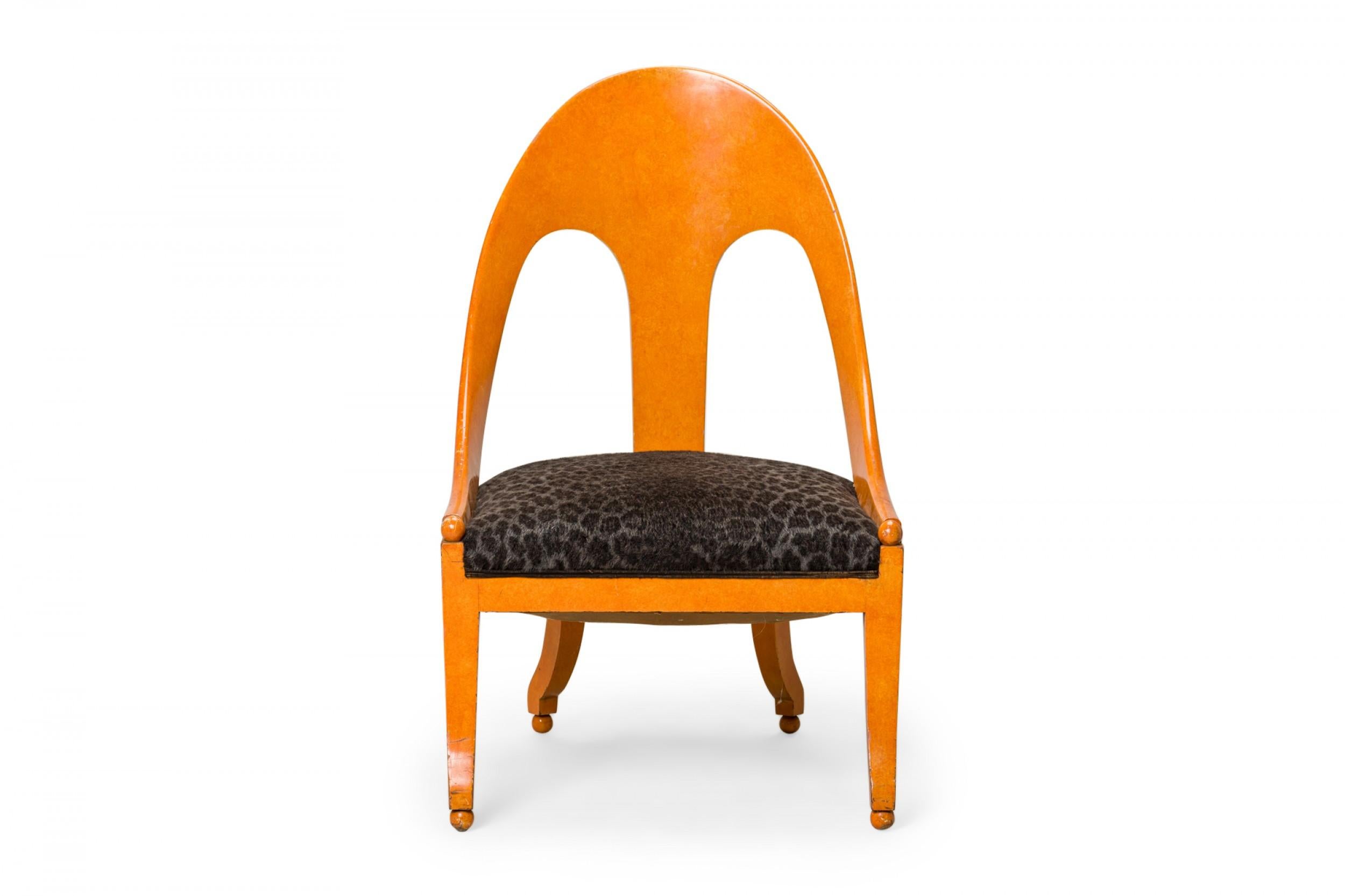 PAIR of American Mid-Century spoon back side / pull up chairs with orange lacquered wooden frames and black leopard print upholstered seats, resting on four square curved legs ending in ball feet. (PRICED AS PAIR)(Similar pieces: DUF0428-DUF0431)