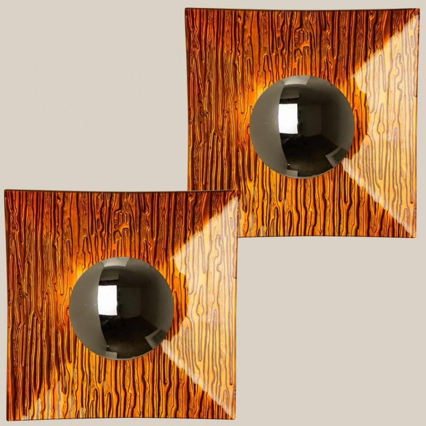 Pair of unusual shapedxa0orange metal wall lights with a with orange glass back plate Space Age wall lights from Italy, 1970s.
Unique 1970s design. This unique pair not only functions as light source but also as a sculptural component.

In excellent