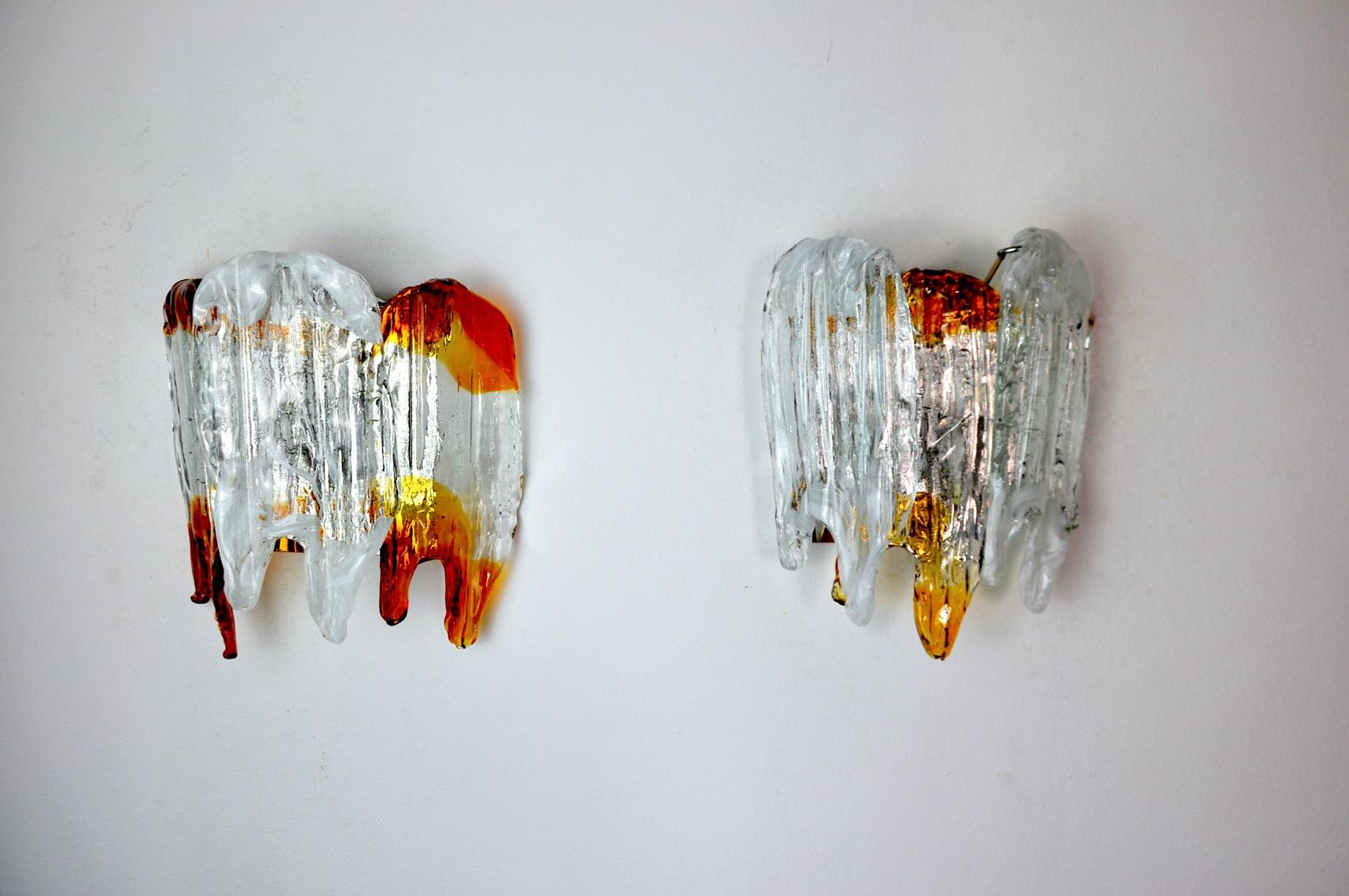 Very beautiful and rare pair of wall lamps designed and produced in murano, italy in 1960. This pair of wall lamps is composed of a chromed metal structure and 3 crystals in built-in murano glass in the shape of flames. Rare design object that will