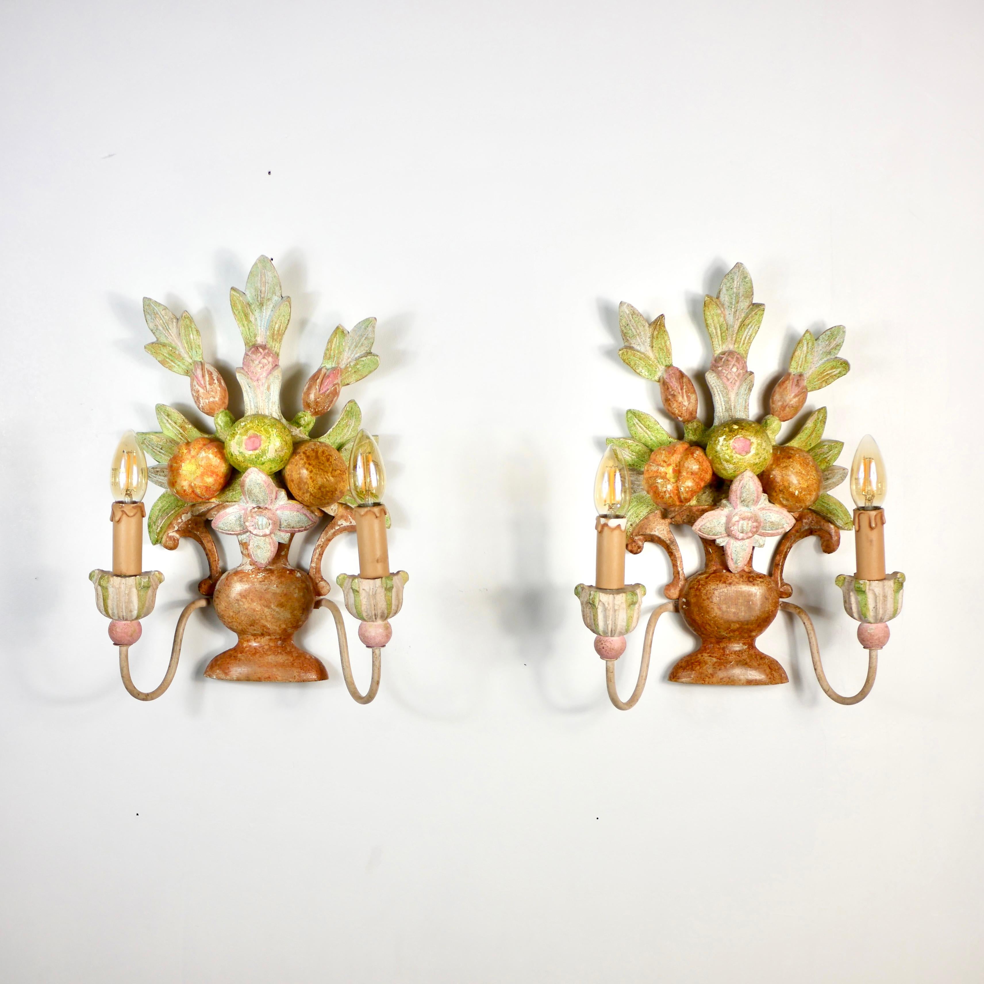 Beautiful pair of hand-carved wood sconces made in Italy in the early 20th century, depicting bunches / baskets of flowers, leaves and fruits, in the style of Maison Jansen.
Hand-painted, each sconce has two metal 