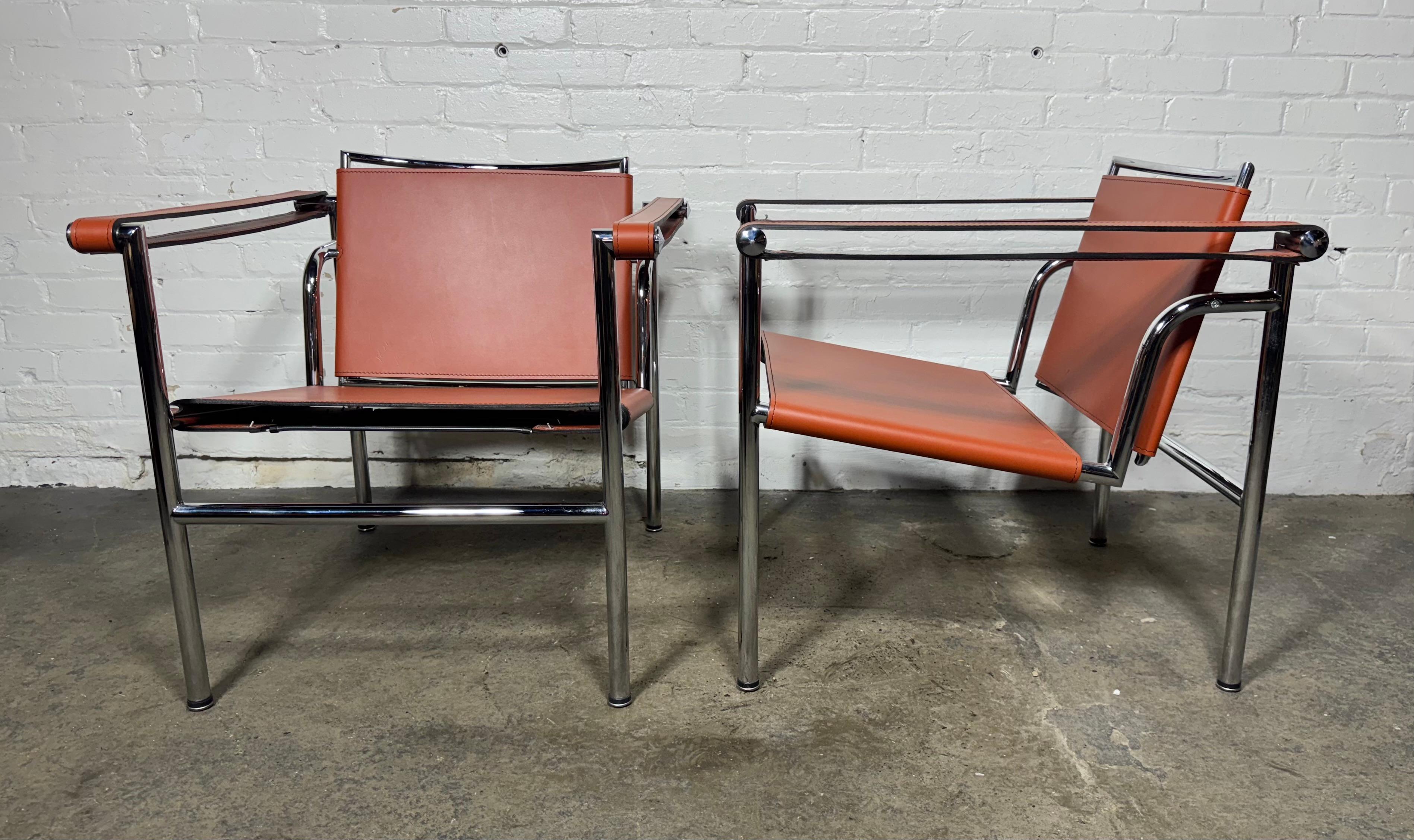 Pair of vintage LC1 orange (pumpkin) leather chairs designed by Le Corbusier, originally designed in  circa 1928  ... originally purchased from Design Within Reach in the late 1990's. Amazing color,, Showroom new condition, Hand delivery avail to