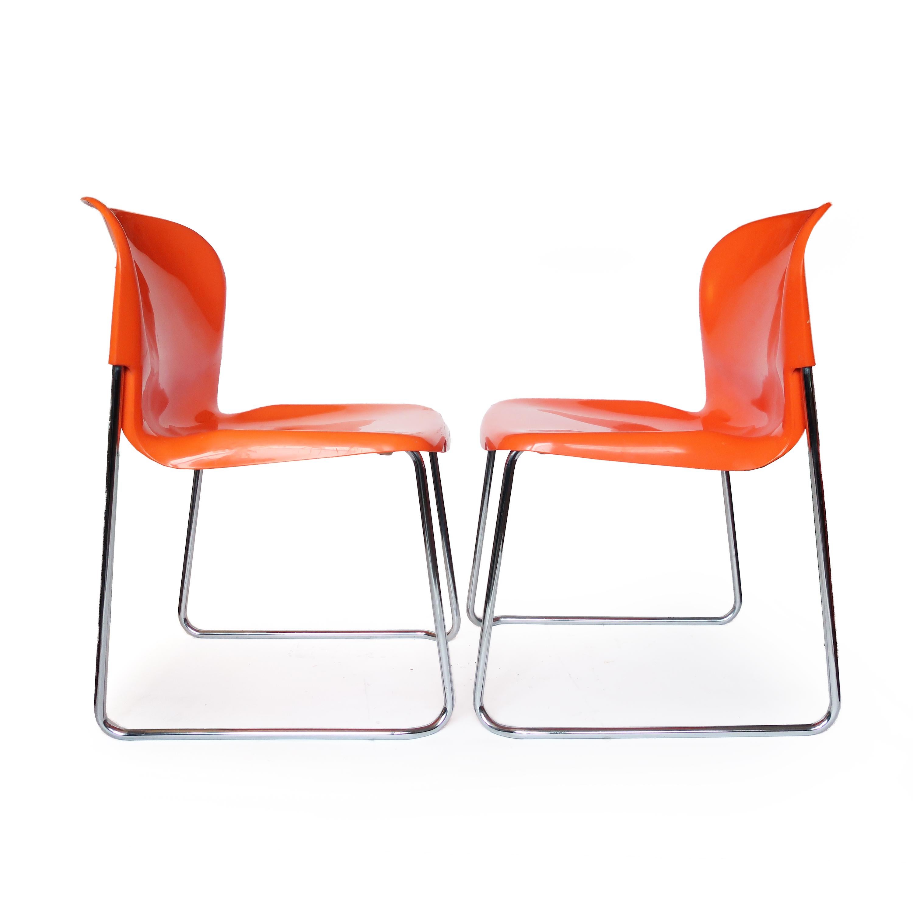 Une paire de chaises SM 400 Swing aux couleurs vives, conçue dans les années 1970 par Gerd Lange pour Drabert, un fabricant de meubles ouest-allemand. Les sièges en plastique moulé orange reposent sur un cadre chromé qui permet de les empiler