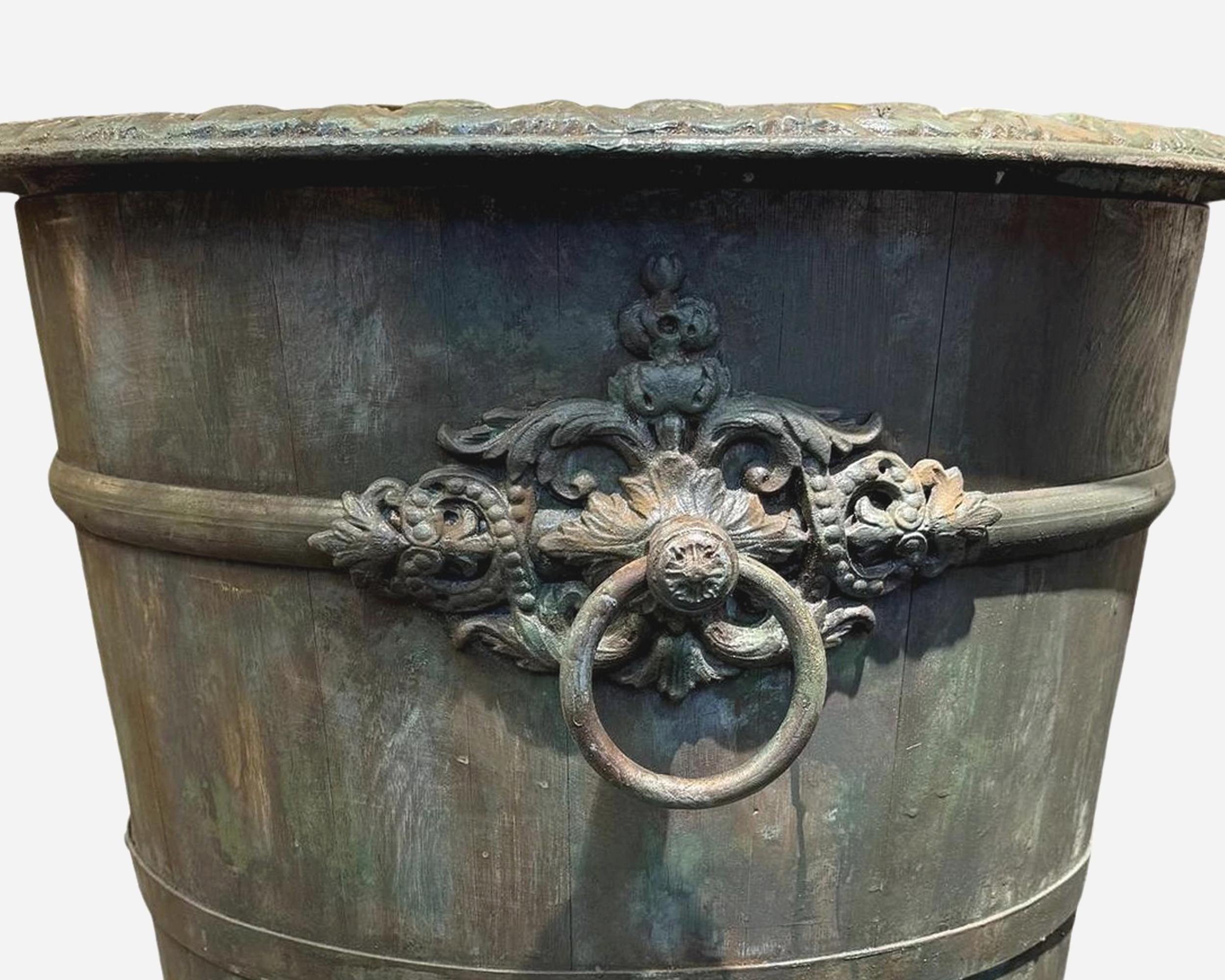 Paire de jardinières pour arbres (orangers, lauriers etc...), en lattes de chêne, cerclage en fer, pieds, poignées et bord supérieur en fonte travaillée.
Fabrication française d'après un modèle du 19e siècle.
Leur construction est la même que celle