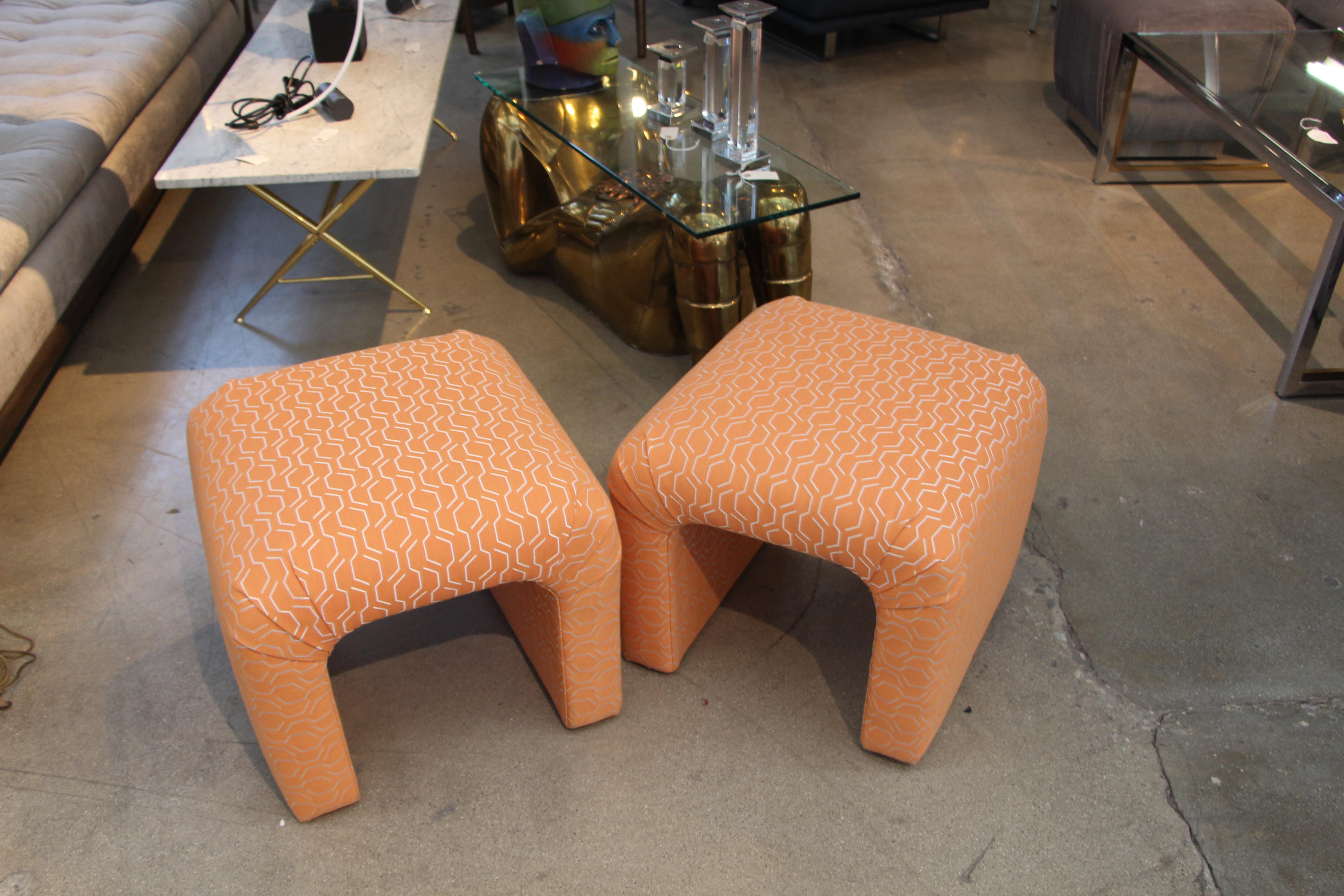 A nice pair of vintage ottomans that have been redone in a nice orange fabric.