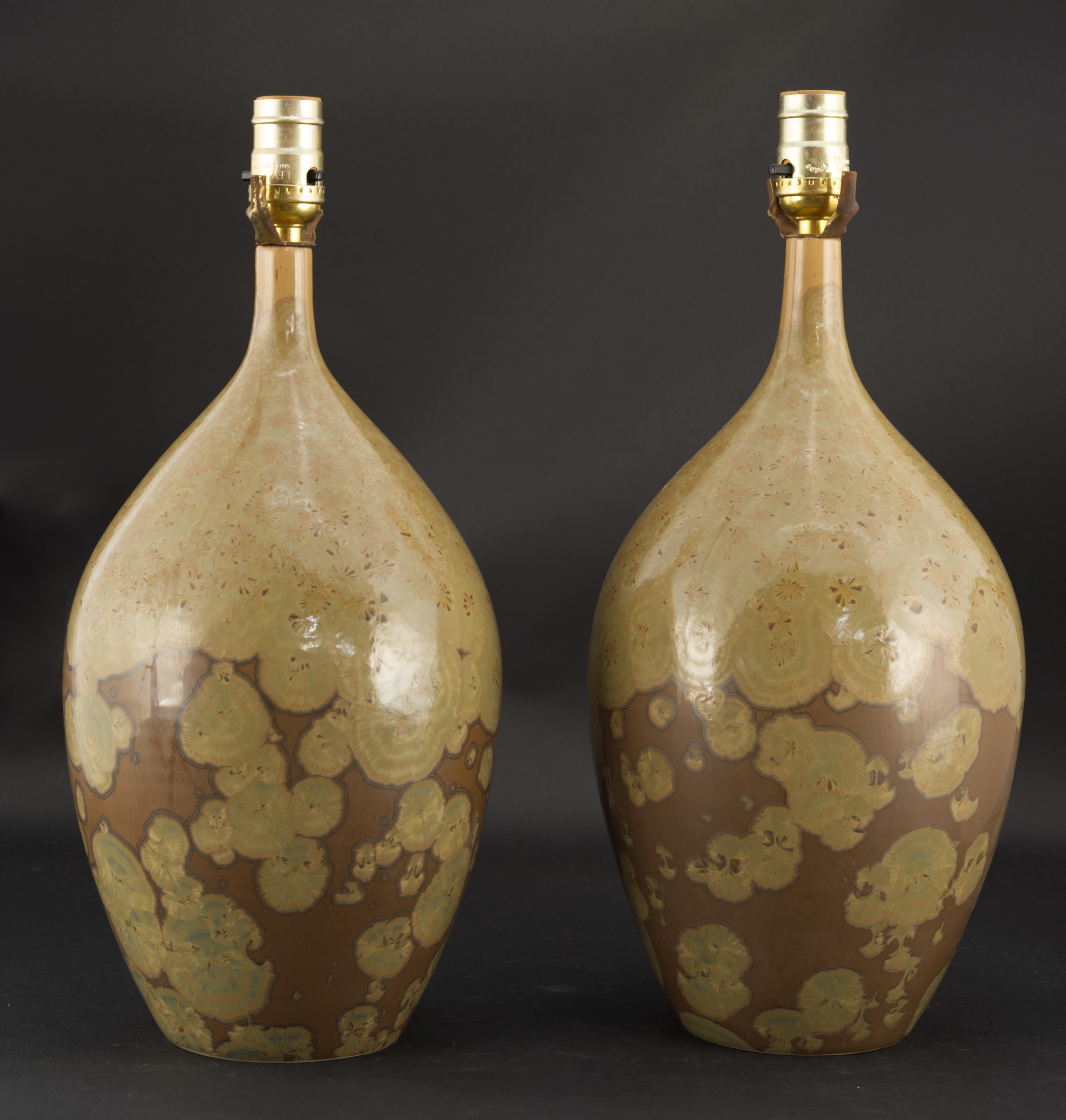 The pair of vintage studio pottery ceramic lamps is decorated with crystalline glaze in organic, earthy tones. The bodies were hand thrown on a wheel; olive color crystals on milk chocolate colored base were grown in a kiln during a very long,