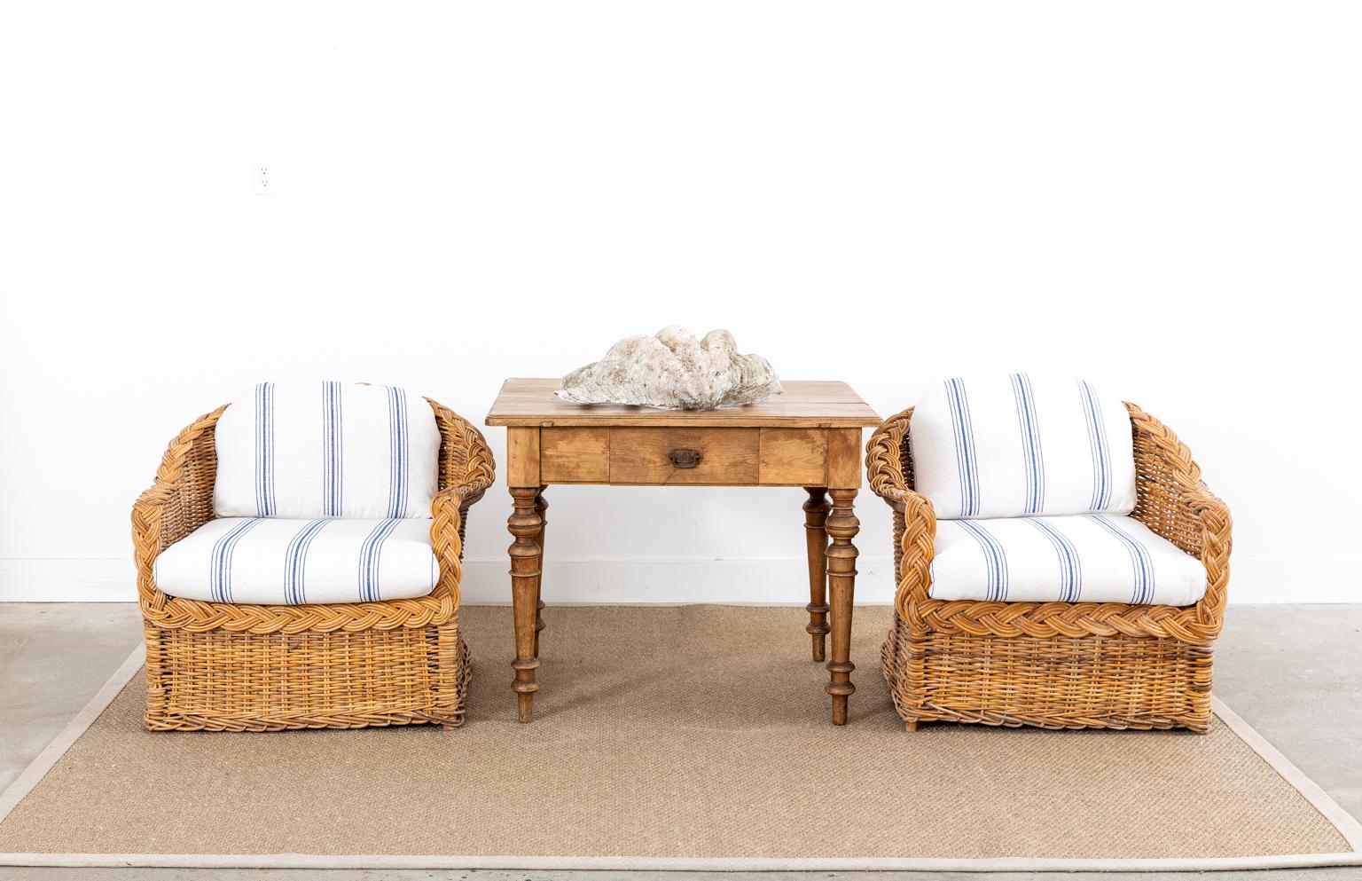 Stylish pair of woven rattan wicker lounge chairs made in the California organic modern style by The Wicker Works in San Francisco, CA. The timeless design features a modern redux of blue and white upholstery. The soft fabric has a French grain sack
