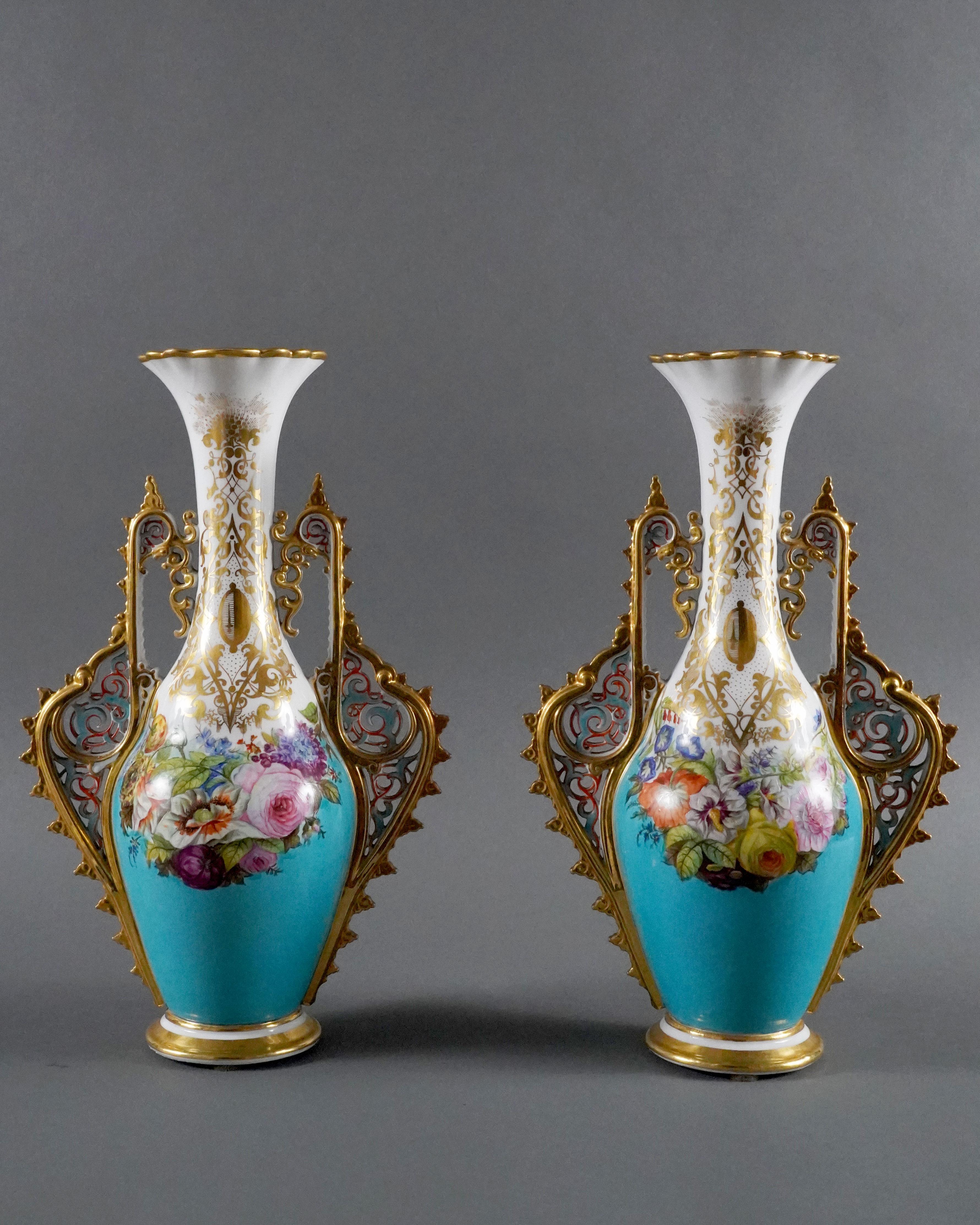 Beautiful pair of amphora vases in white and blue porcelain, richly decorated on each side with beautiful polychrome floral compositions framed by handles with openwork motifs of oriental scrolls inspired by Alhambra decorations. The necks and feet