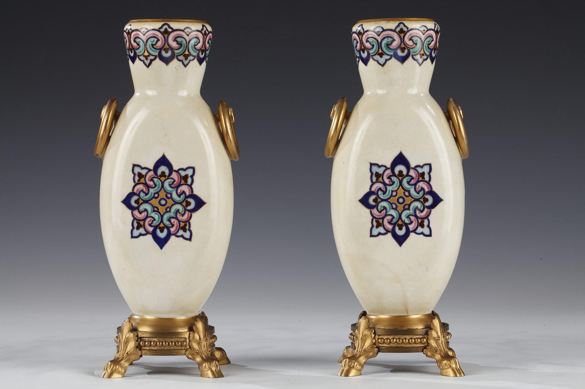 Signed RSA Bellanger

Small pair of polychrome enamel and ivory ceramic vases with gold-rimmed neck, decorated with trompe-l’œil handles in the shape of rings. They are adorned on the belly of painted orientalist water carrier and zither player in