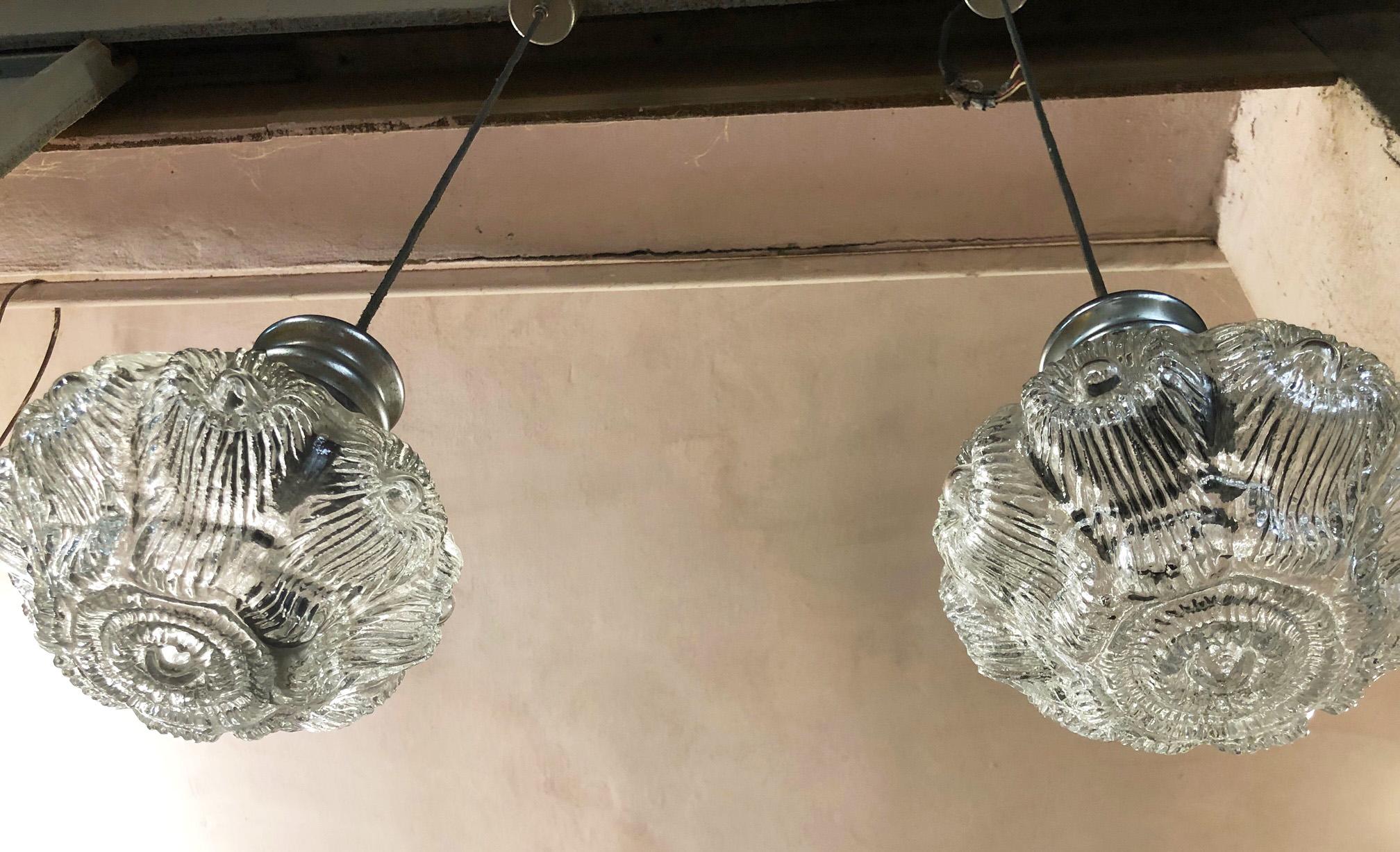Pair of original 1960s chandeliers with a very beautiful floral-shaped glass and chromed attachments.
The total height is 90 cm.
Comes from an old country house in Lucca area of Tuscany.
The paint is original in patina.
As shown in the