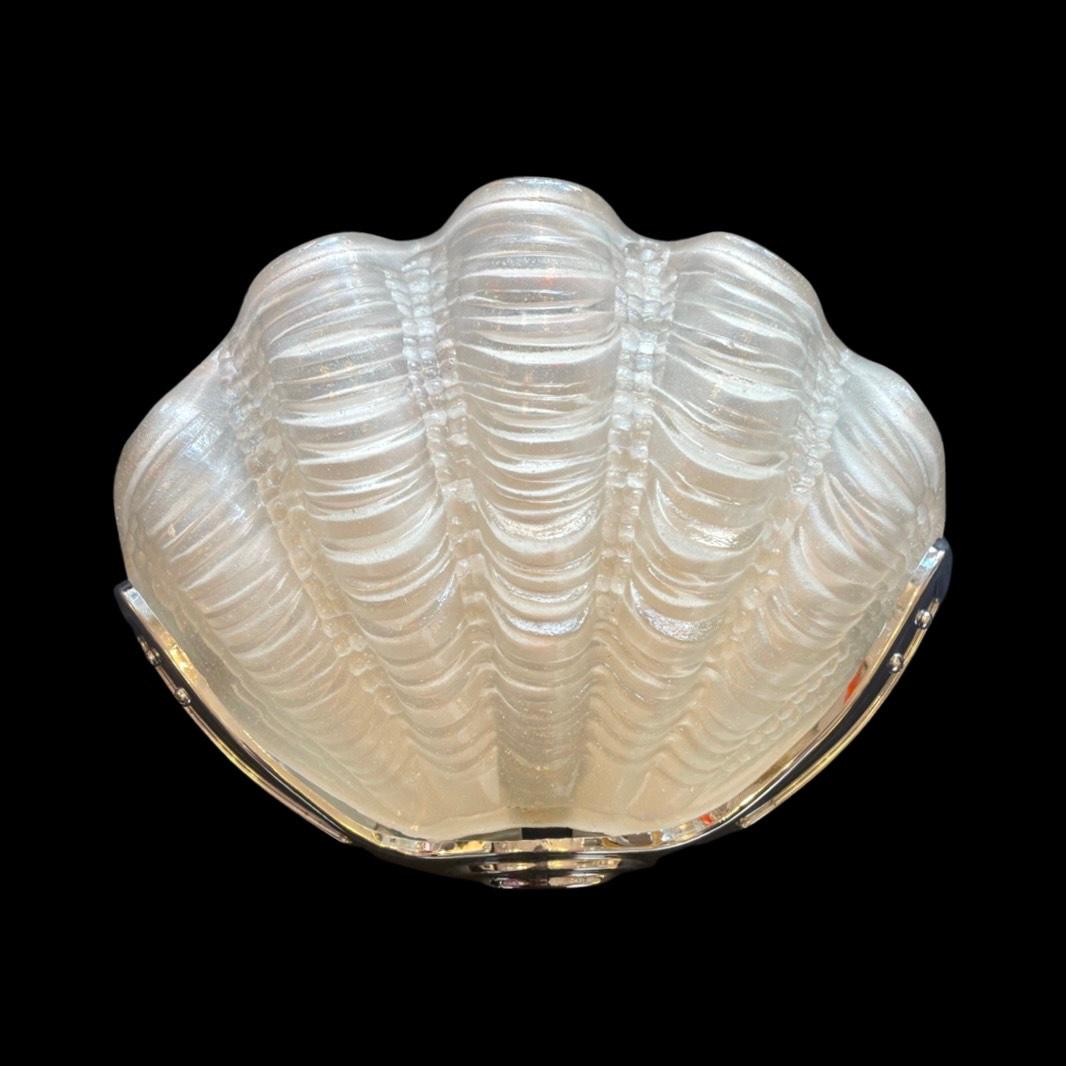 A pair of Original Antique Art Deco Odeon Clam Shell Wall Lights.

The ethereal white frosted rippled glass, delicately encased within a lustrous chrome frame, casts a soft, enchanting glow that ascends gracefully upwards.

Transporting you to the