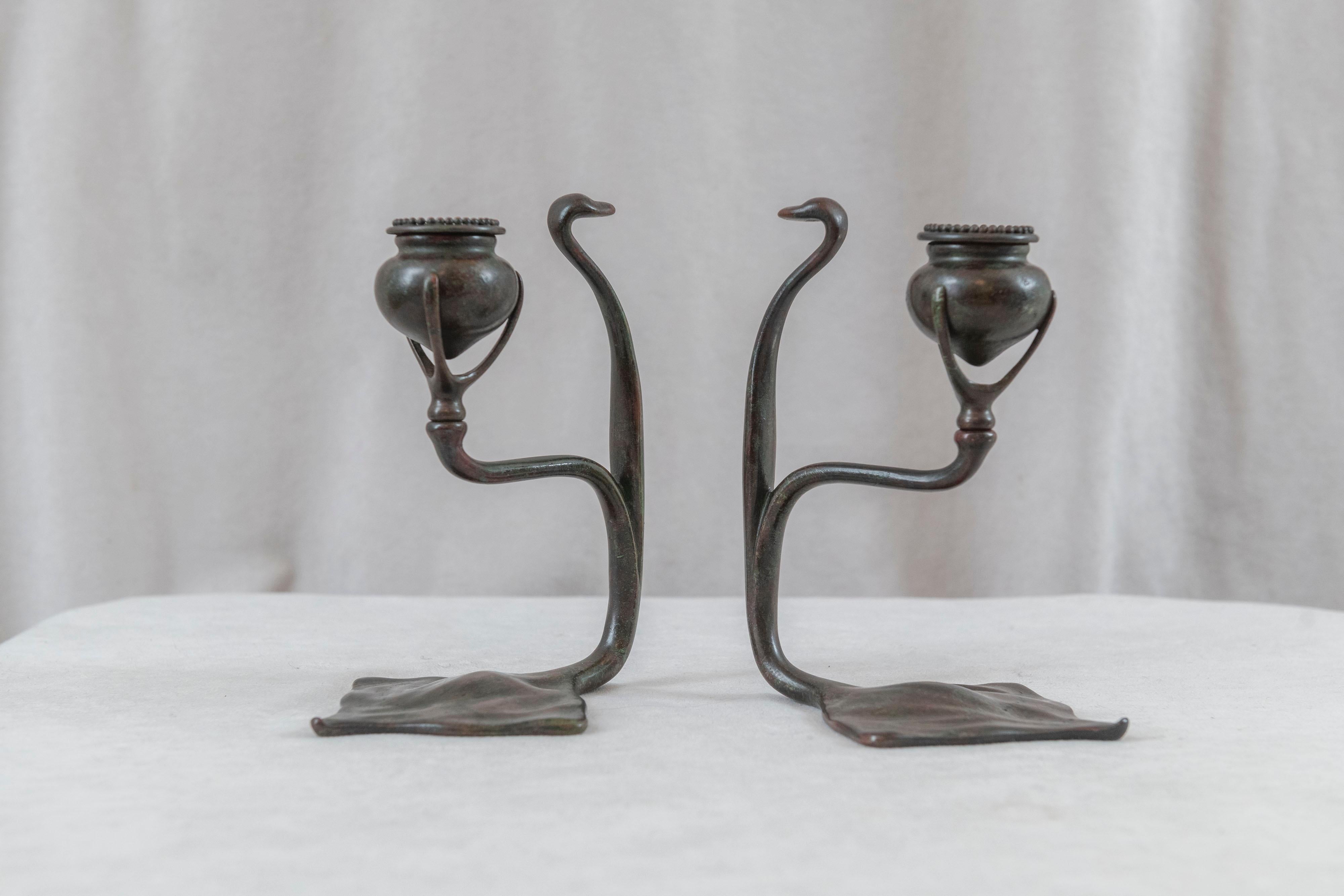  If you are looking for a pair of Tiffany candlesticks these are hard to beat. Beautifully cast and richly patinated with reddish brown with green highlights that Tiffany was known for. The graceful design has the look of a cobra, hence the