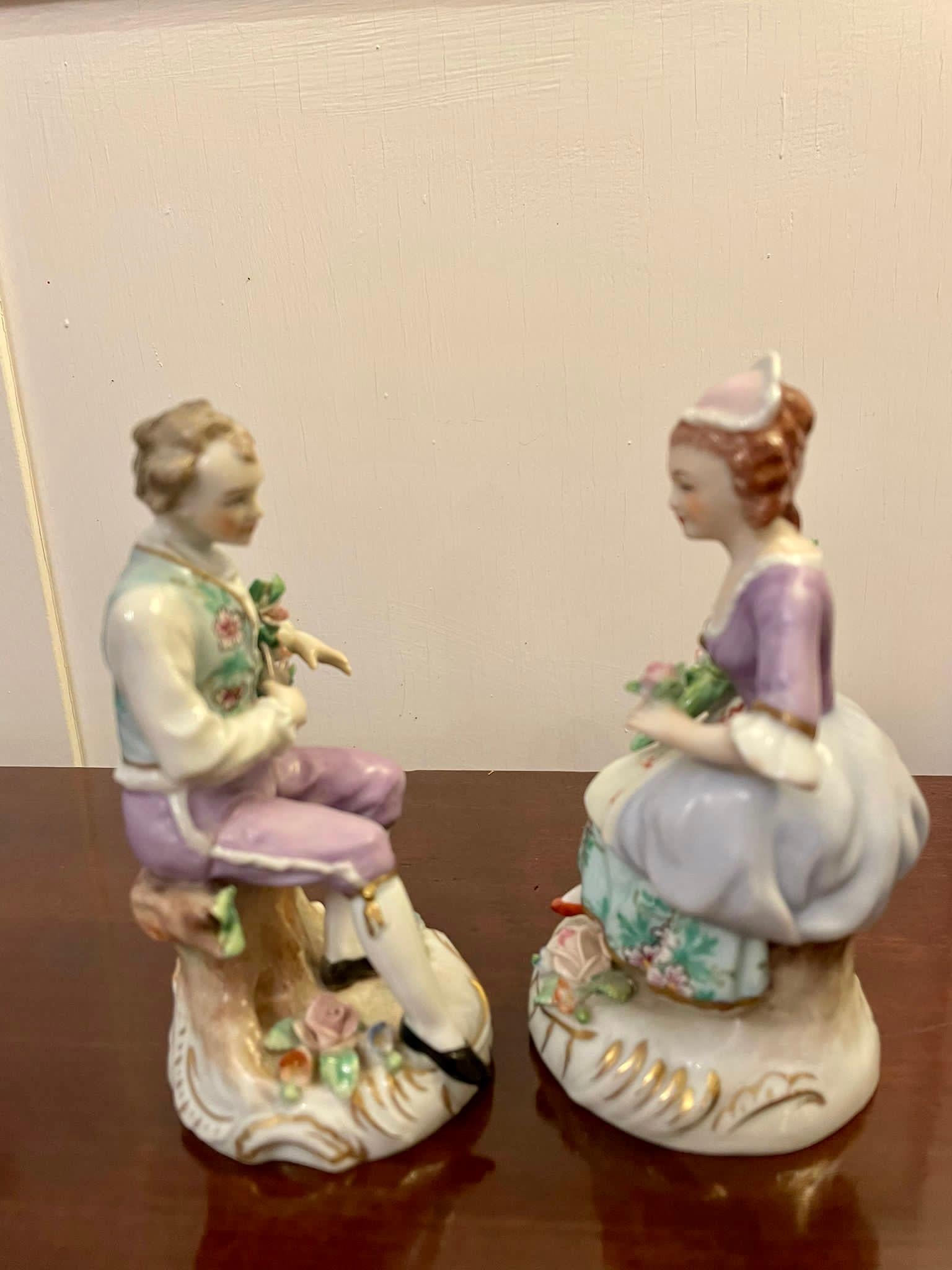 Pair of original antique Victorian Sitzendorf figures 
Pair of original antique Victorian Sitzendorf figures of a gentleman reclining on a tree stump pruning roses, the lady also seated with a bouquet of flowers and a single rose in the opposite