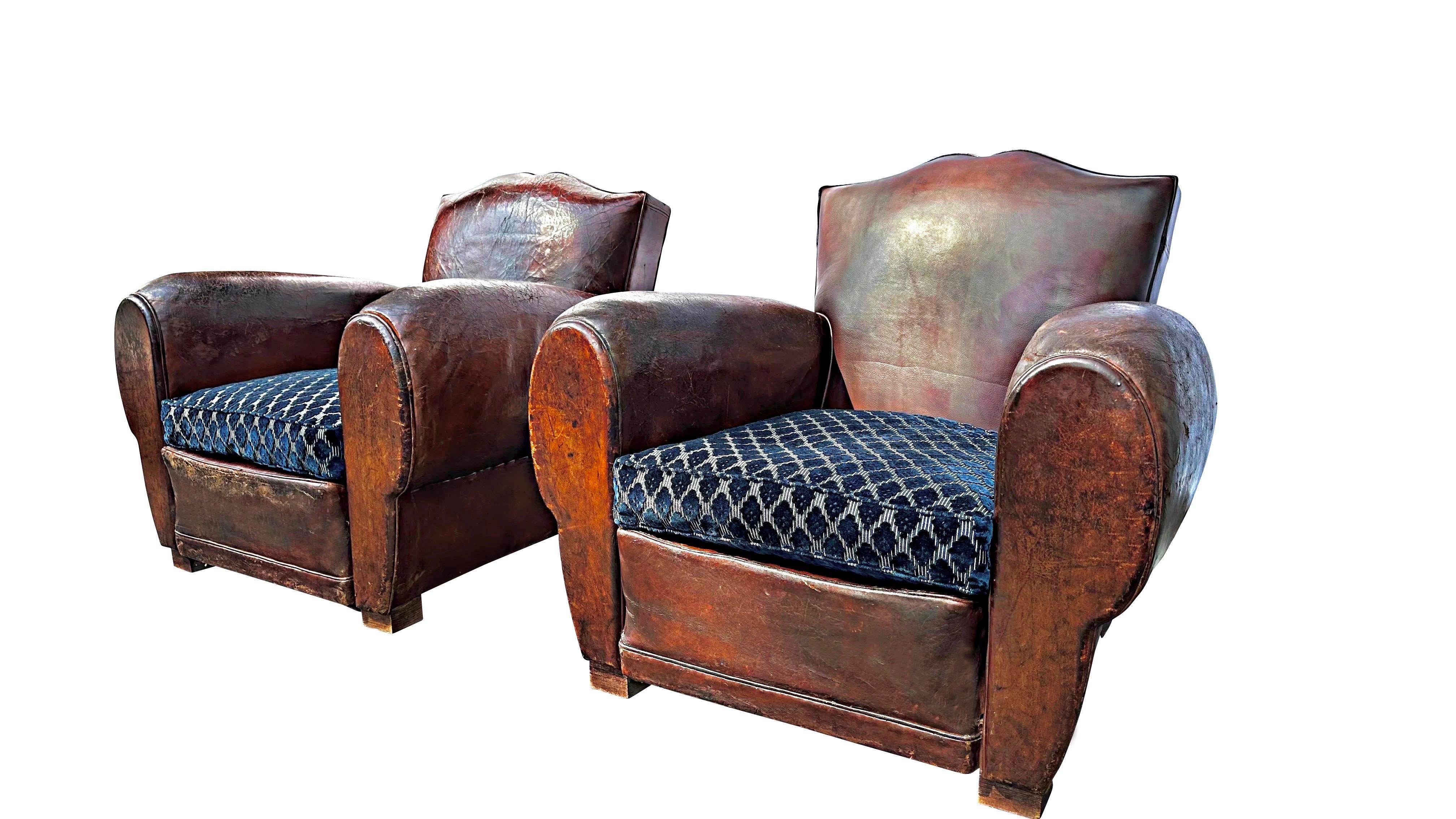 A pair of original 1930’s Art Deco French Moustache leather club chairs.  These highly sought-after chairs radiate character and charm, combining style with exceptional comfort. Their beautiful patina showcases just the right amount of wear,