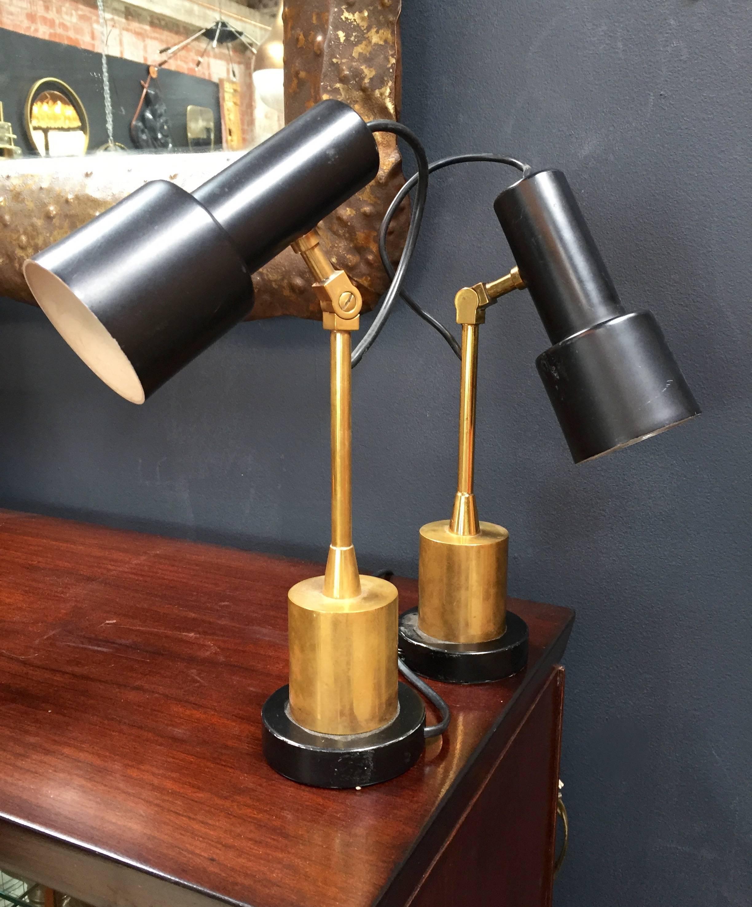Pair of rare articulated Italian Stilnovo table lamps in brass with black metal round base.
The single lamp is composed by three swivels to be adjusted in height and rotating metal shade painted on black.
The shade has one bulb creating a nice