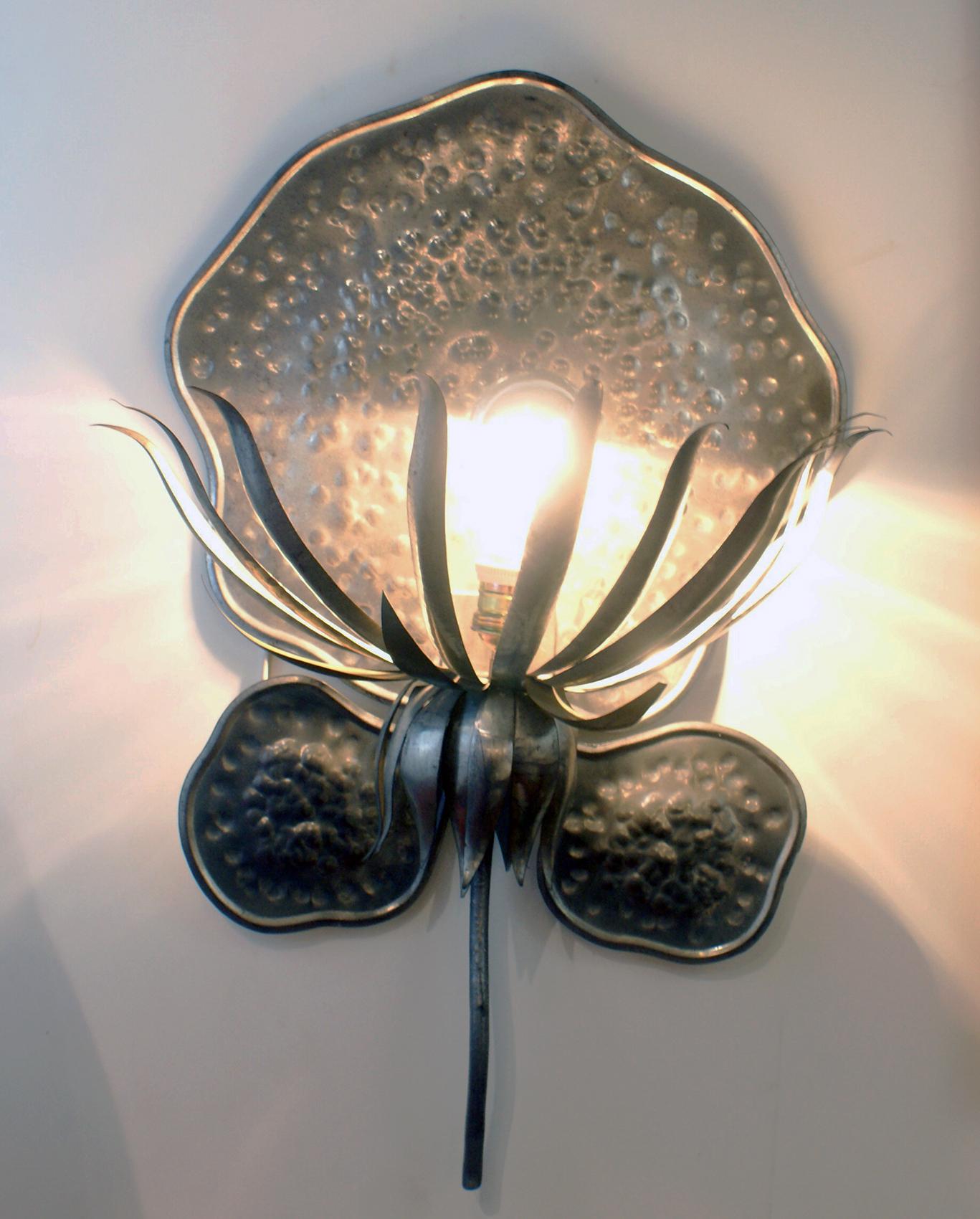 Unusual and decorative pair of modern design sconces, featuring hammered plaque (clover shape) and foliage in silver metal, matching to the sconce one light bulb, each with a 100 Watts max.
Can be delivered and wired for American or European