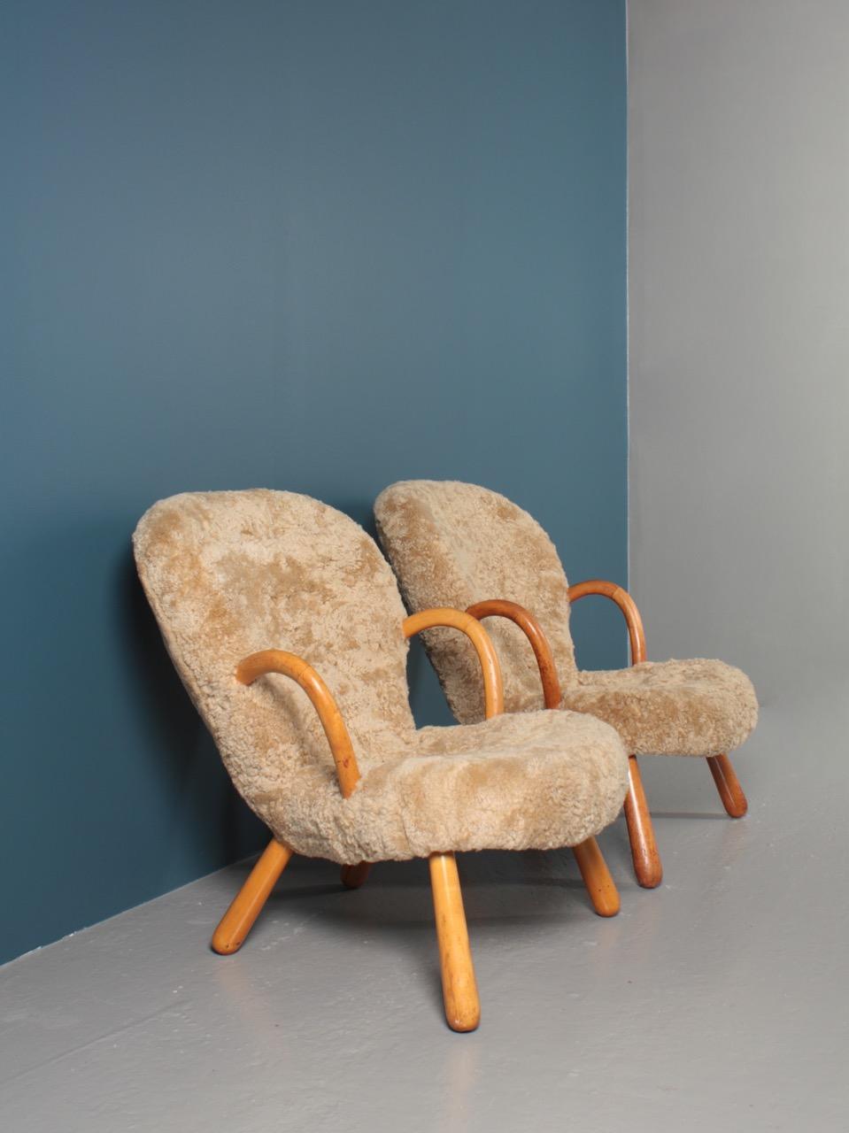 Pair of lounge chairs with round armrests and legs of patinated beech. Seat and back upholstered with sheepskin. Designed by Danish architect Philip Arctander for Nordisk Staal- & Møbel Central in 1944. This pair is made in the 1950s and are in