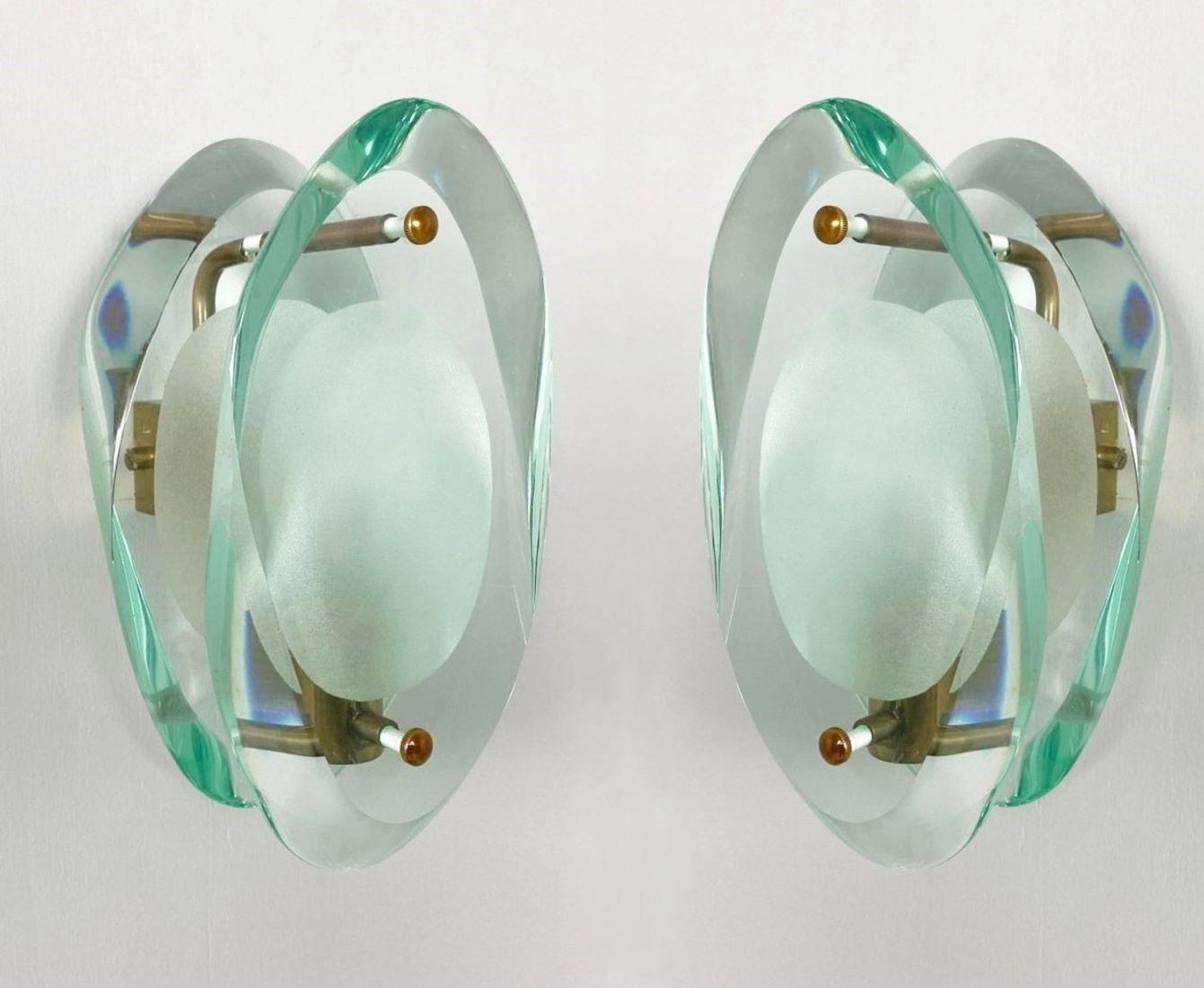 Pair of light sconces by Max Ingrand for Fontana Arte, Model 2093, Italy, 1960-1961. Organically shaped double lens cut panels of thick Murano profiled polished Murano glass with etched glass centers, polished brass mounted. The Model 2093 is one of