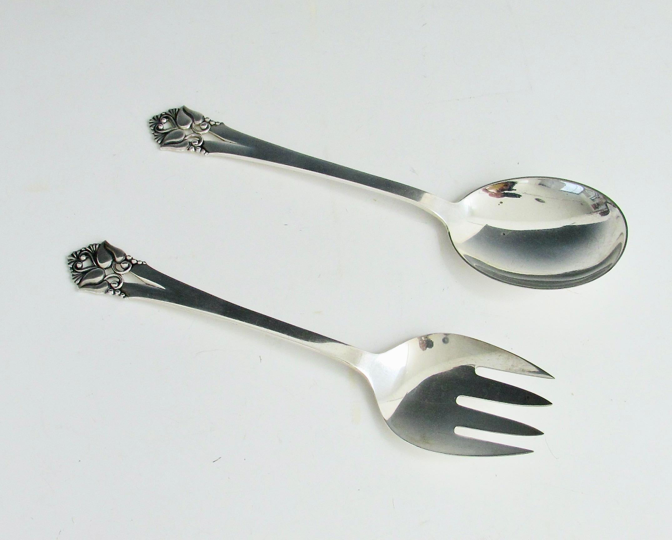 Paire de pièces de service  fourchette et cuillère estampillées O. Mogensen Denmark Sterling .  Orla Vagn Mogensen  était un orfèvre danois travaillant à Copenhague entre 1949 et 1975. 
Orla Design/One a également été l'un des principaux créateurs