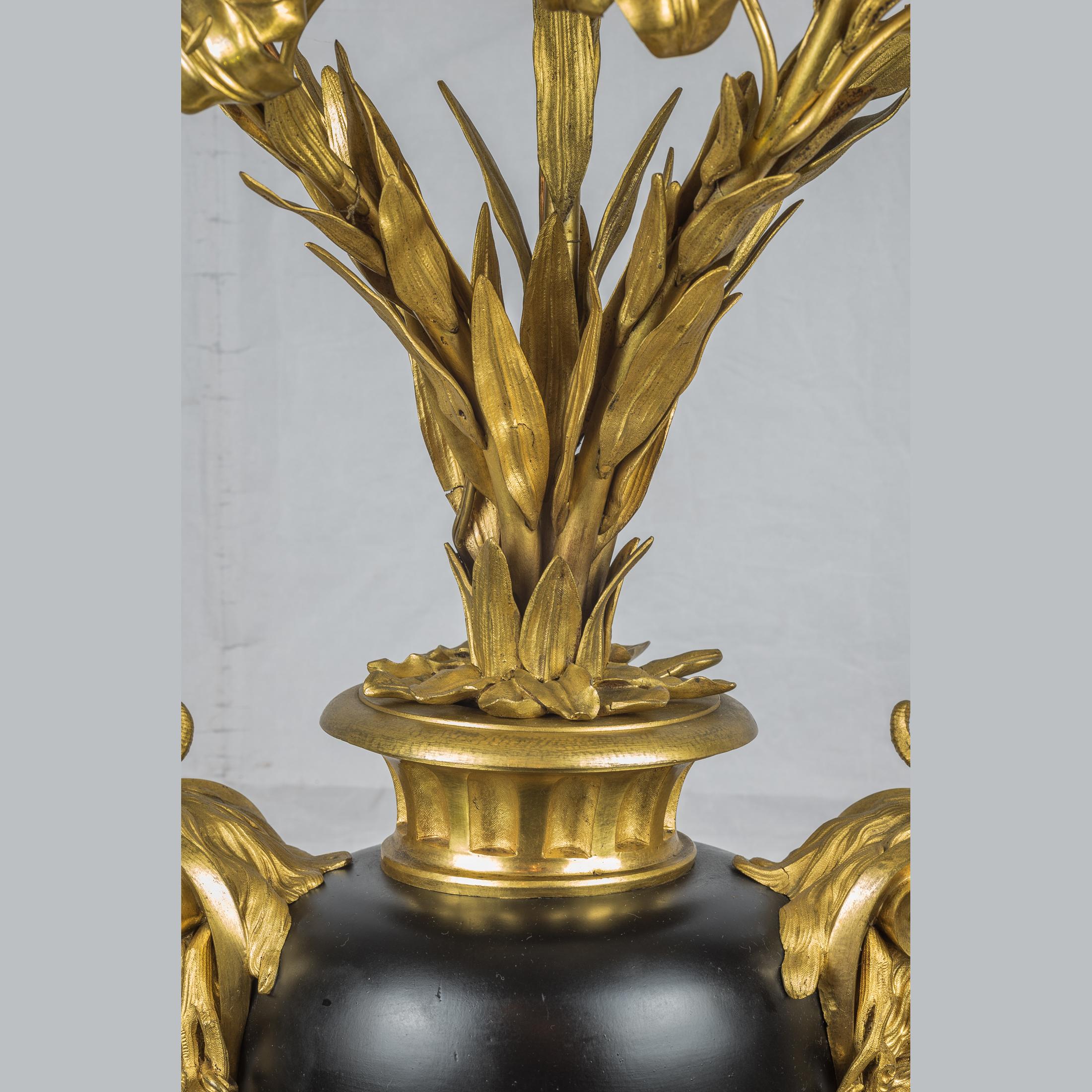 Doré Paire de candélabres en bronze doré et à cinq lumières avec bras à fleurs et poignée en forme de tête de bélier en vente