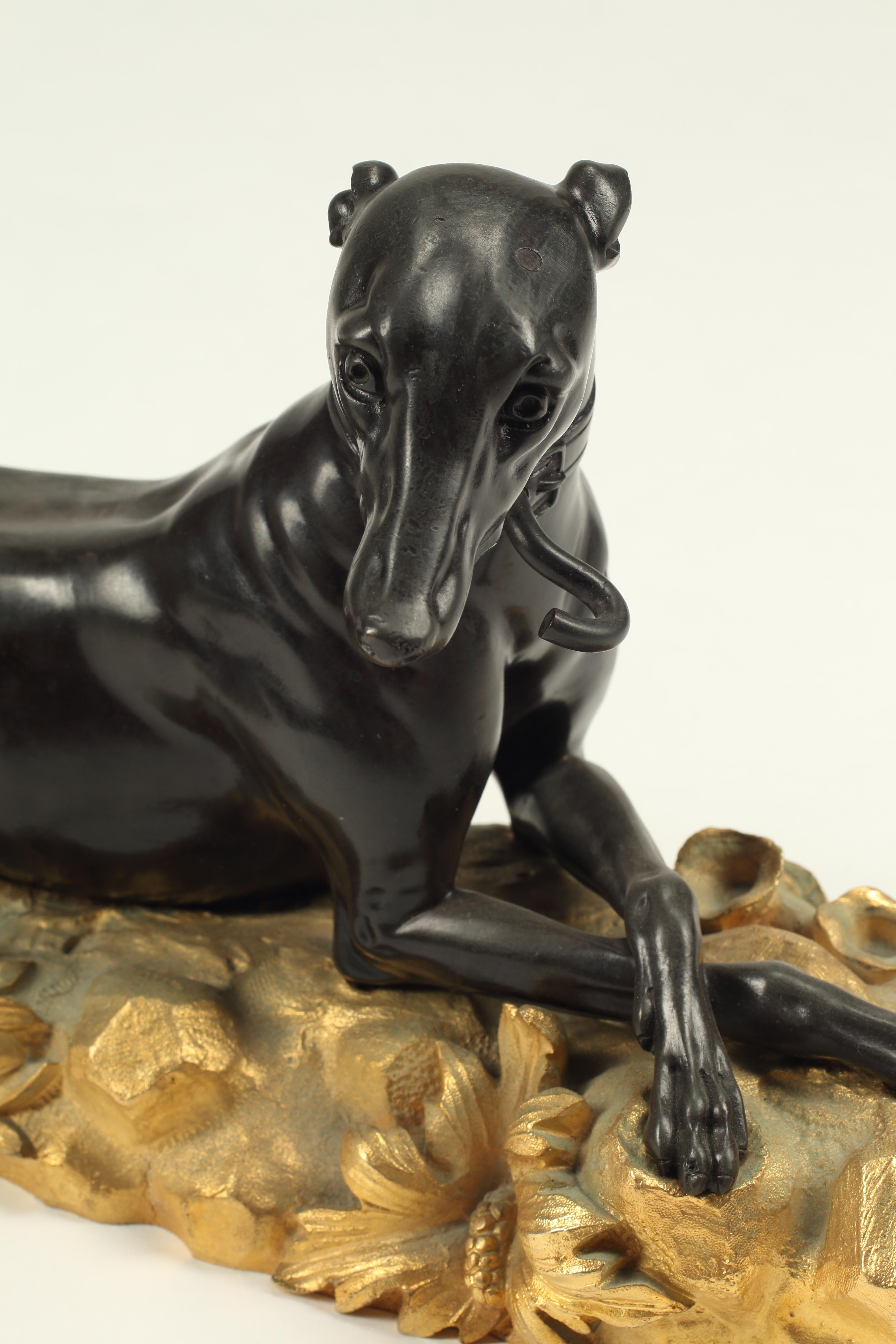 Una favolosa coppia di chenet (androni) francesi del XIX secolo con levrieri fusi in bronzo patinato su basi in ormolu. I levrieri sono delicatamente scolpiti per guardarsi l'un l'altro attraverso il camino e le basi in bronzo ormolano incorporano