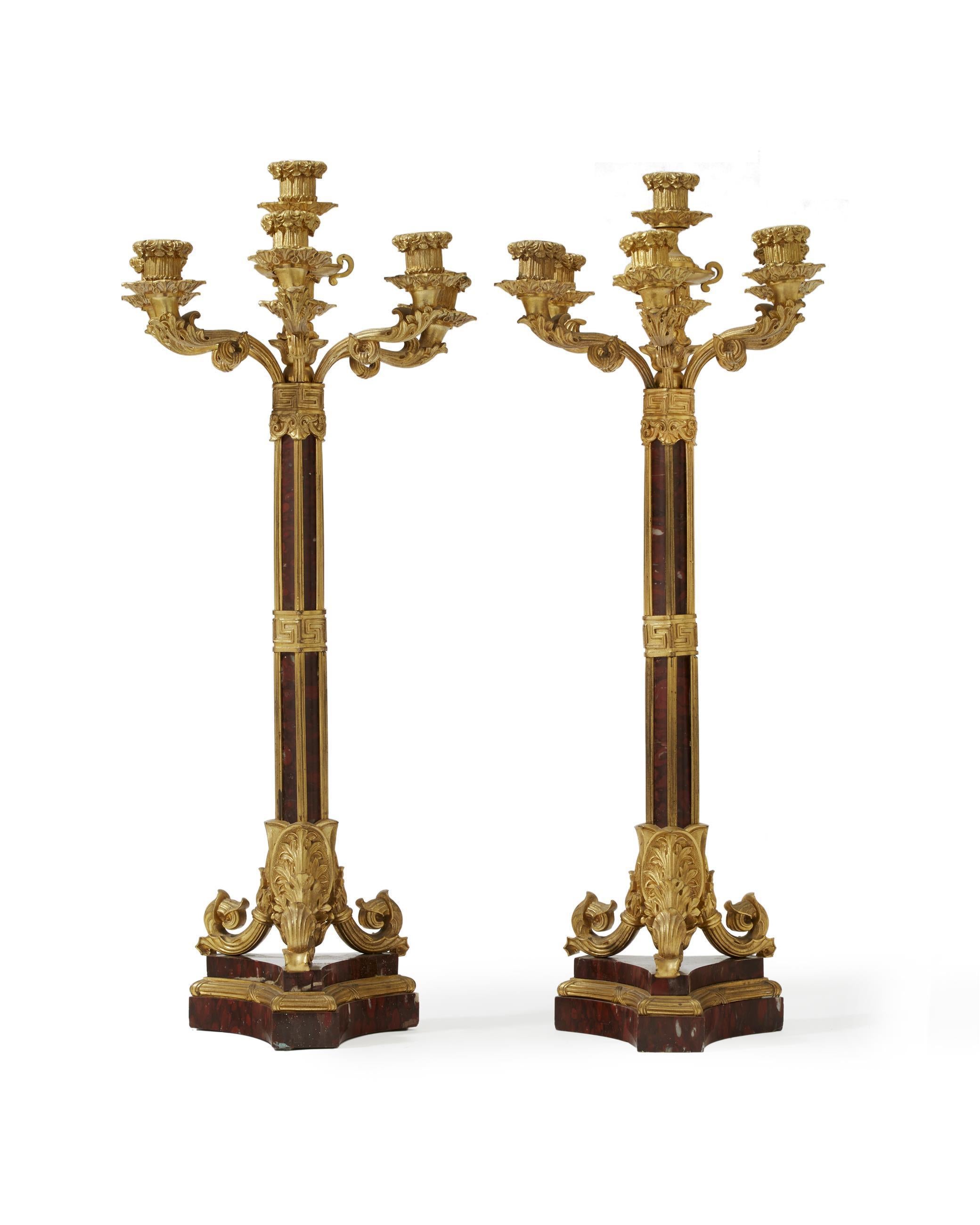 Unique pair of French ormolu and rouge marble candelabra.
Late 19th century. 

The candelabra is with seven foliate-inspired arms terminating in gilt bronze dishpan and candleholder, above a mixed rouge marble and ormolu shaft decorated in Greek