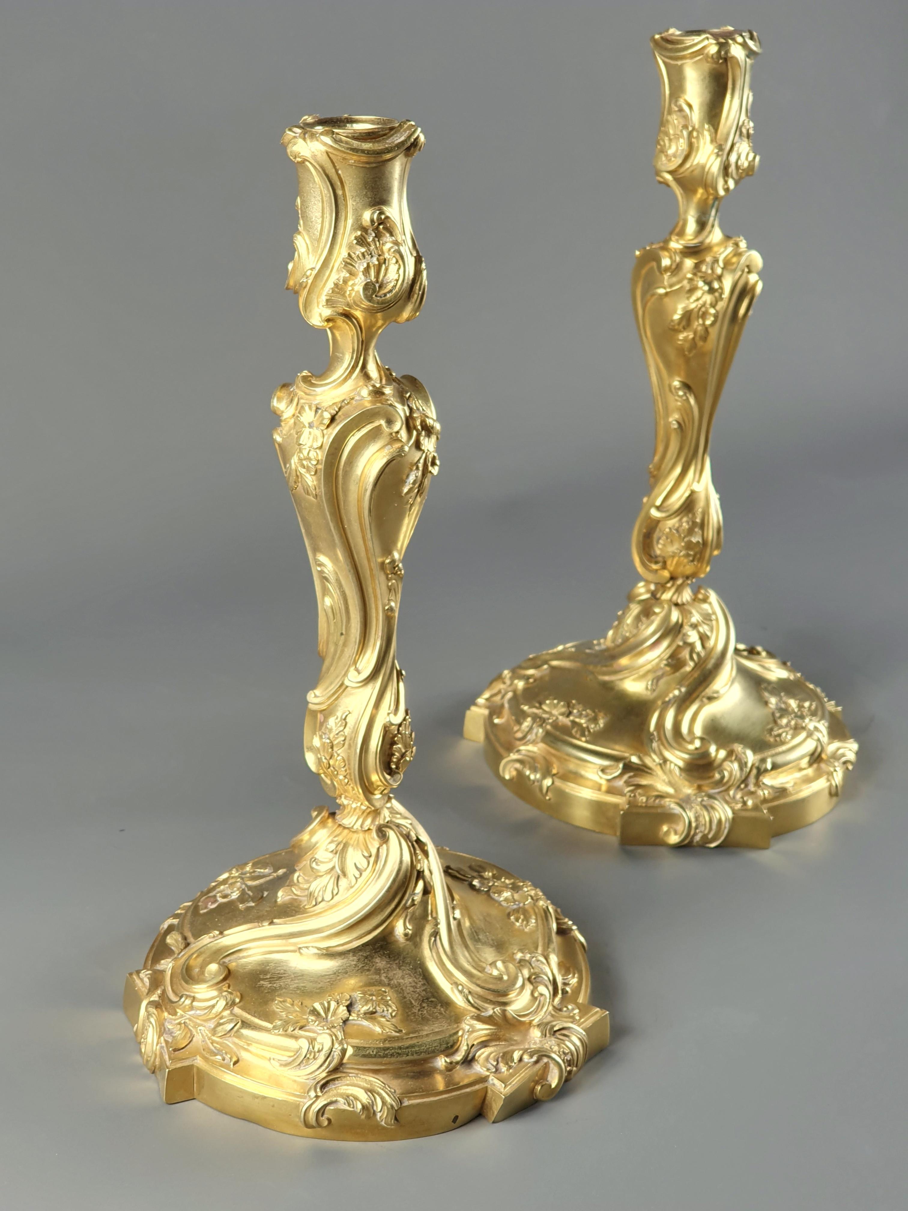 Paar Louis XV Rocaille Stil Kerzenständer in sehr fein gemeißelt vergoldeter Bronze mit Rollen, Rollen und Blumen verziert.

Pariser Werk des 19. Jahrhunderts von hervorragender Qualität.

Unleserlicher Stempel (HD?), möglicherweise Henry Dasson.
