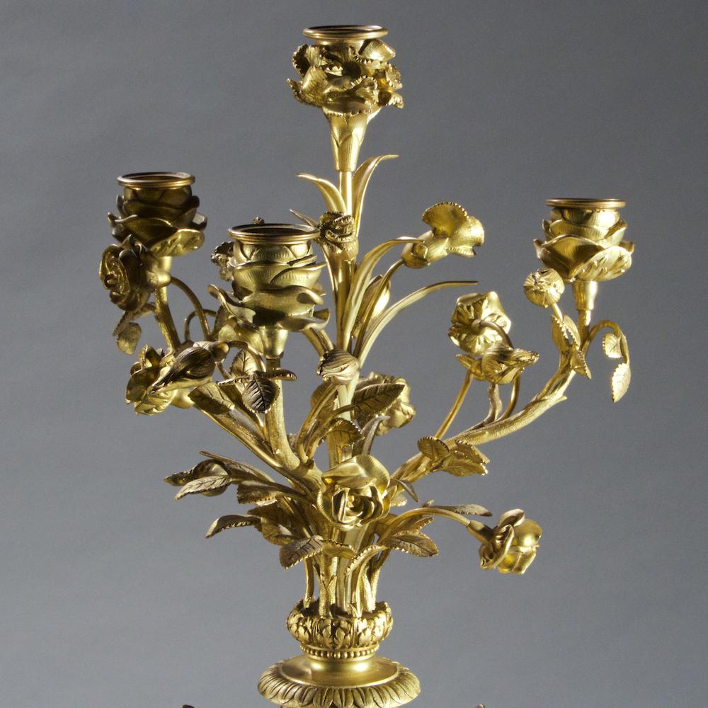 Très belle paire de candélabres Louis XVI à quatre lumières, montés en bronze doré et en marbre. Chacune est ornée de branches de roses feuillagées, d'une forme d'urne en marbre rose et de trois pieds se terminant par des sabots.

Date : 19ème