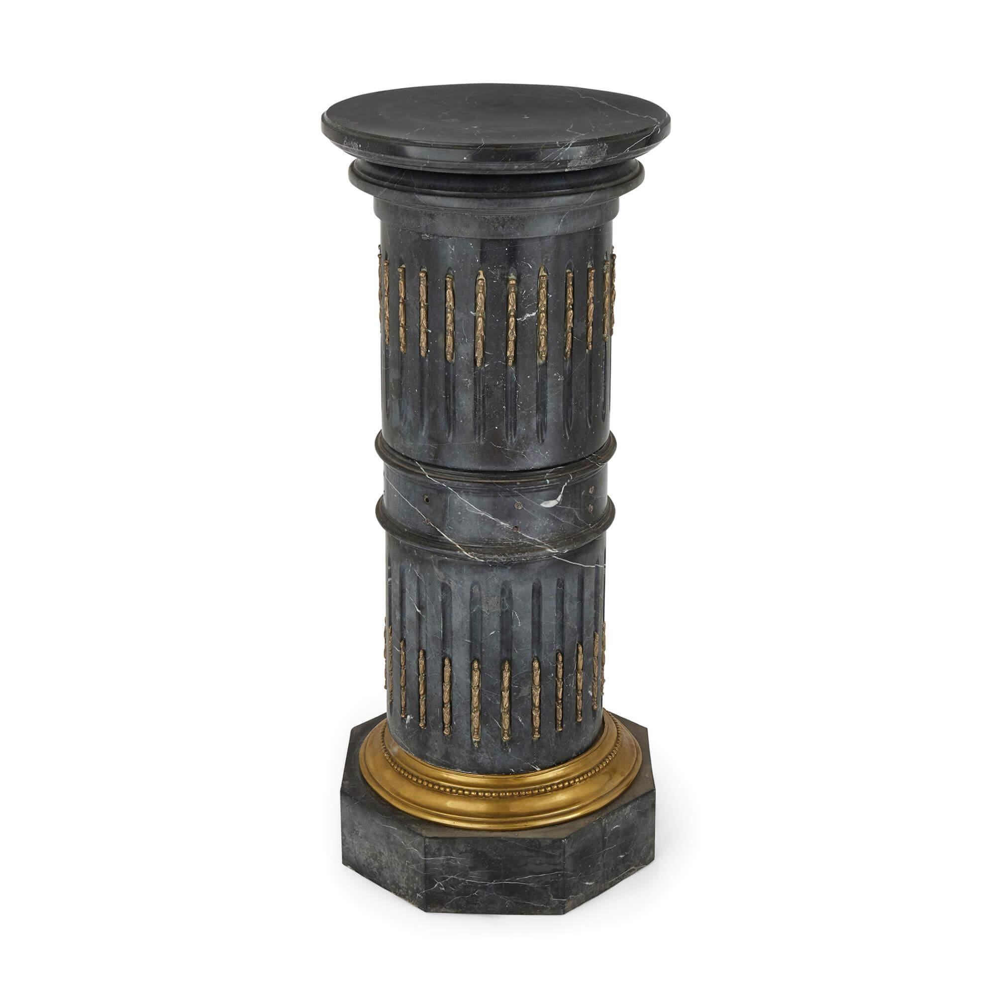 A pair of gilt-bronze and black marble antique Neoclassical pedestals
French, 19th Century
Height 103cm, diameter 45cm

Mounted upon large hexagonal bases adorned with gilt-bronze, this fine pair of Neoclassical pedestals are of baluster form, and