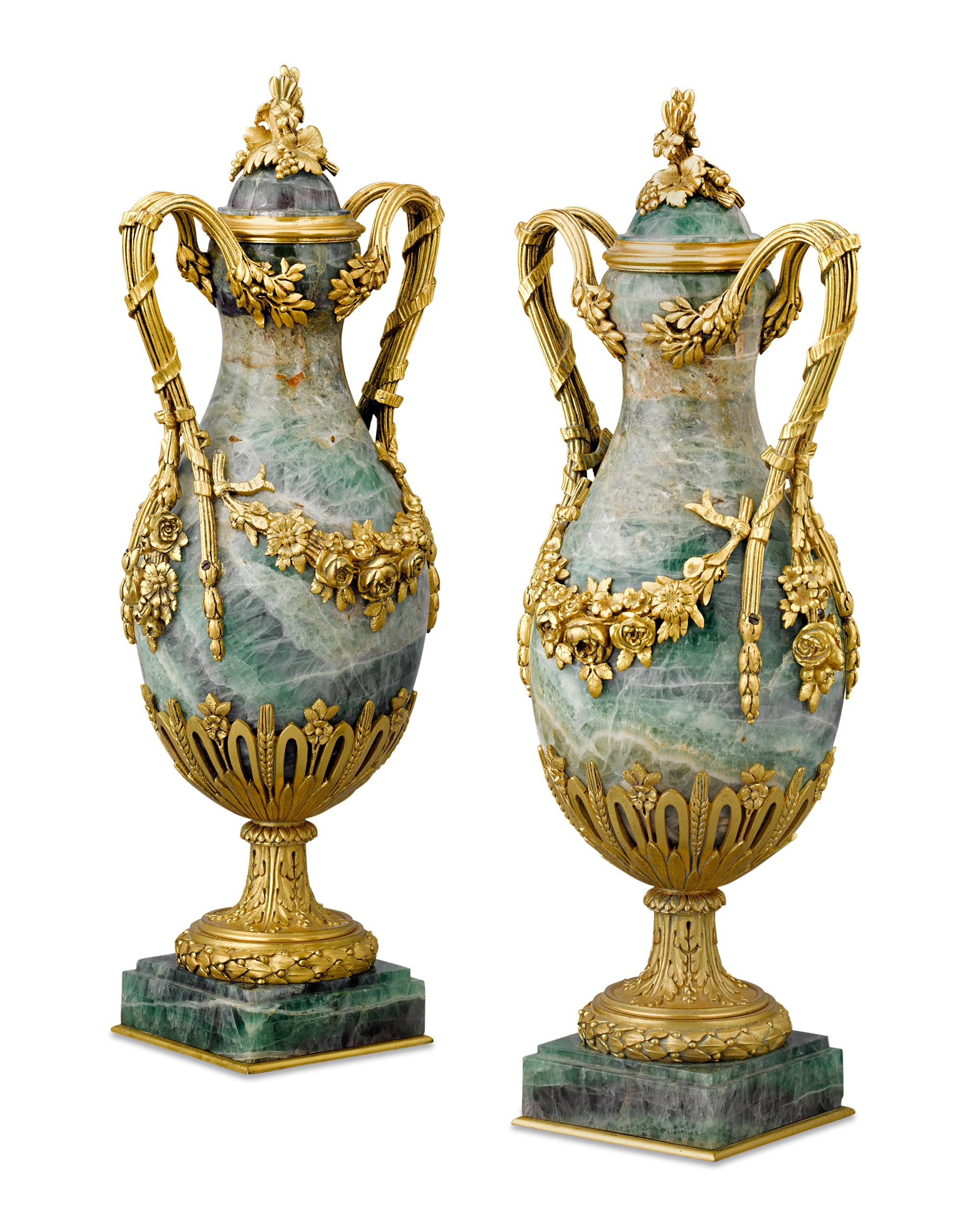 These Napoleon III French urns exemplify the elaborate revival styles that dominated the Second Empire. The baluster-form fluorspar vases are adorned by ormolu mounts in the form of twin handles and garlands of flowers and grapes, evoking the