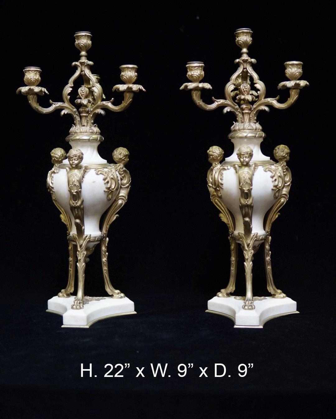 Impressive pair of 19th century French ormolu mounted marble figural candelabras. Each candelabra issuing four foliate inspired arms terminating in foliate decorated candle holder, above a carved white marble body mounted with three ormolu putti
