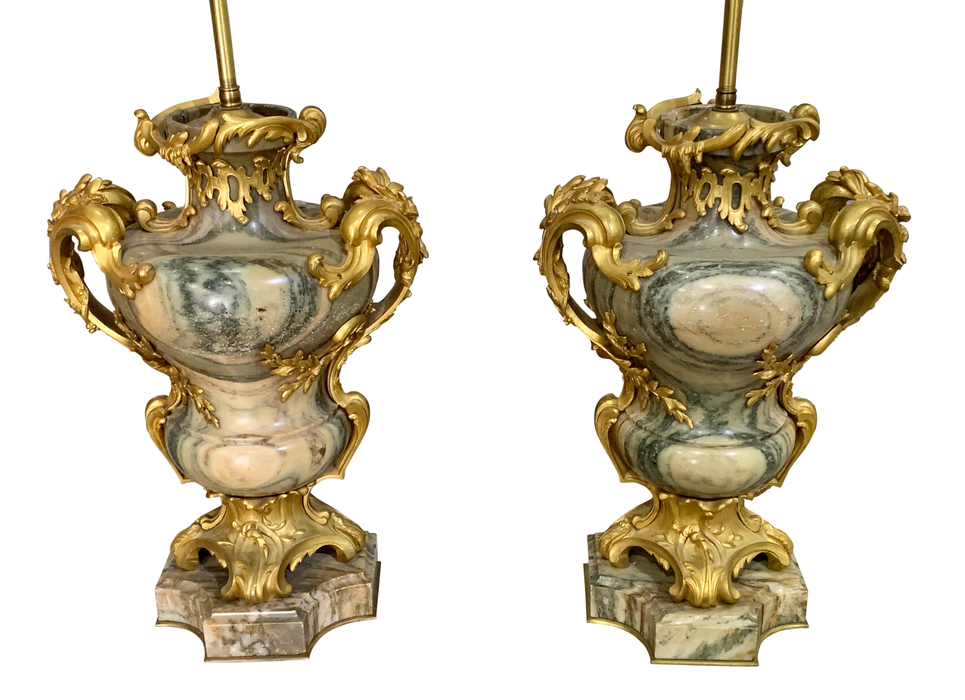 A lovely pair of 19th century French Louis XV style gilt-bronze mounted Cipollino marble urns masterfully made by Maison Millet, now mounted as lamps. Each Cipolin Antique de Grèce marble vase with twin foliate-cast handles, on a scrolled base and