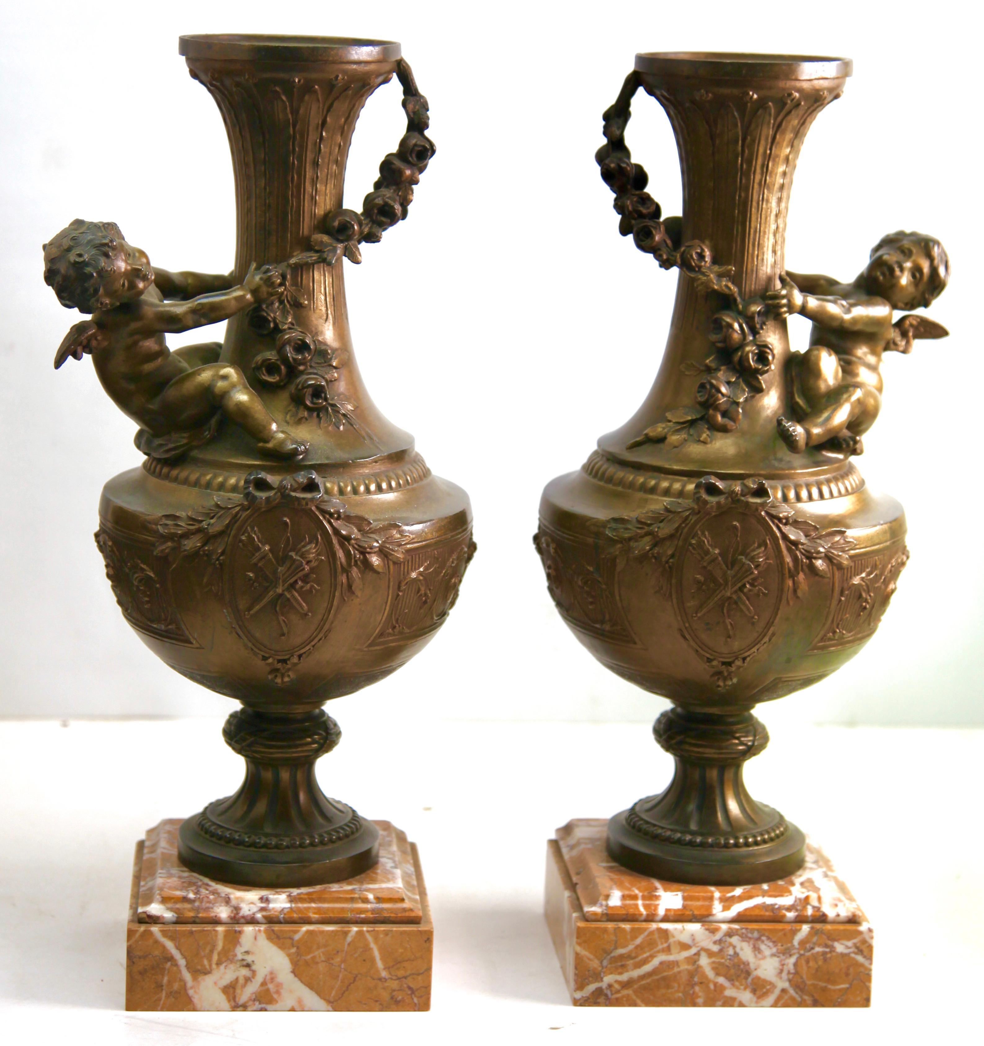 Paar verschnörkelte Vasen oder Lampen mit kleinen Engeln und reich verzierten Motiven (Gegossen) im Angebot