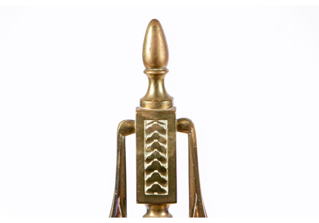 Fine pair of brass fireplace andirons with finial details on the top and lower base.They have an Egyptian feel with etchings, flowing tent sides and a soldier like stance with an unusual form and details.

Dimensions: 22” high x 22” deep by 9.25”