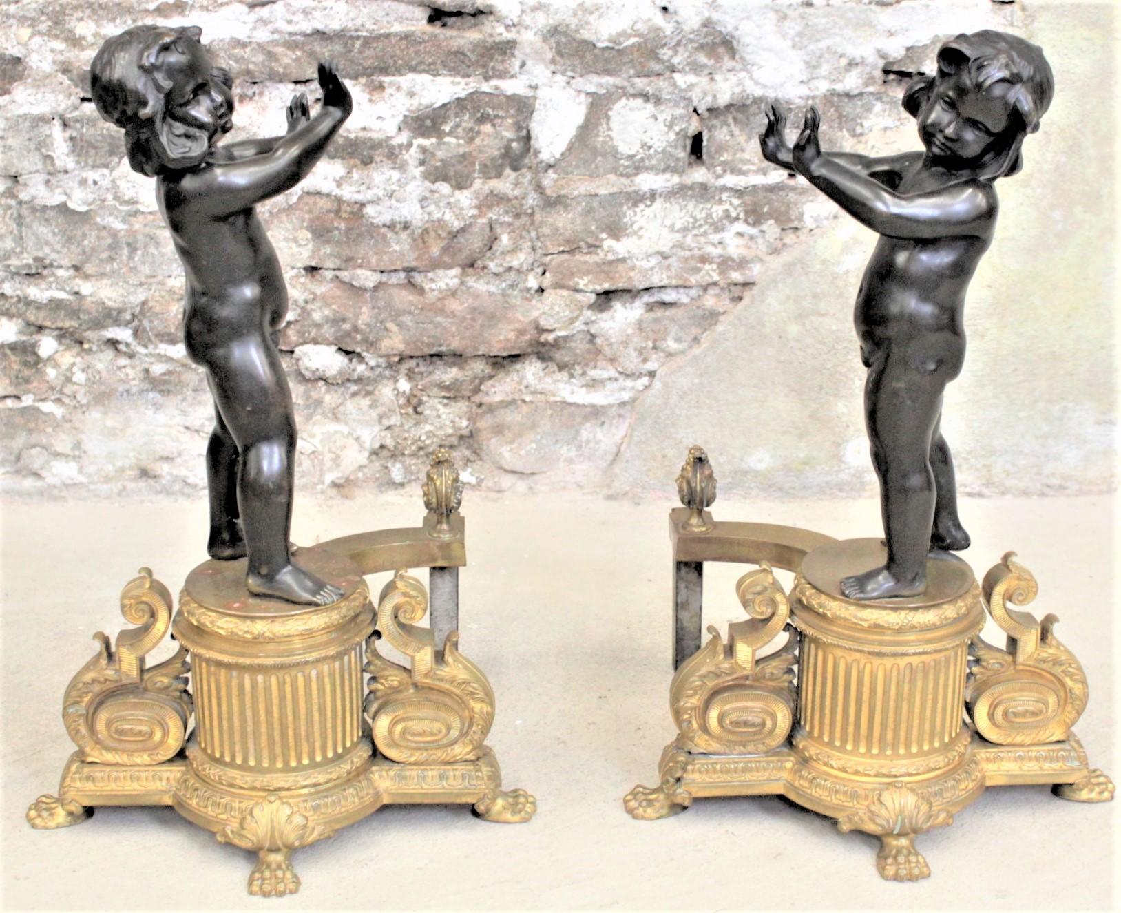 These very large and substantial pair of figural patinated and gilt bronze chenets are unsigned, but presumed to have been made in France in circa 1850 in the Louis XVI style. These unique andirons feature standing children holding their hands and