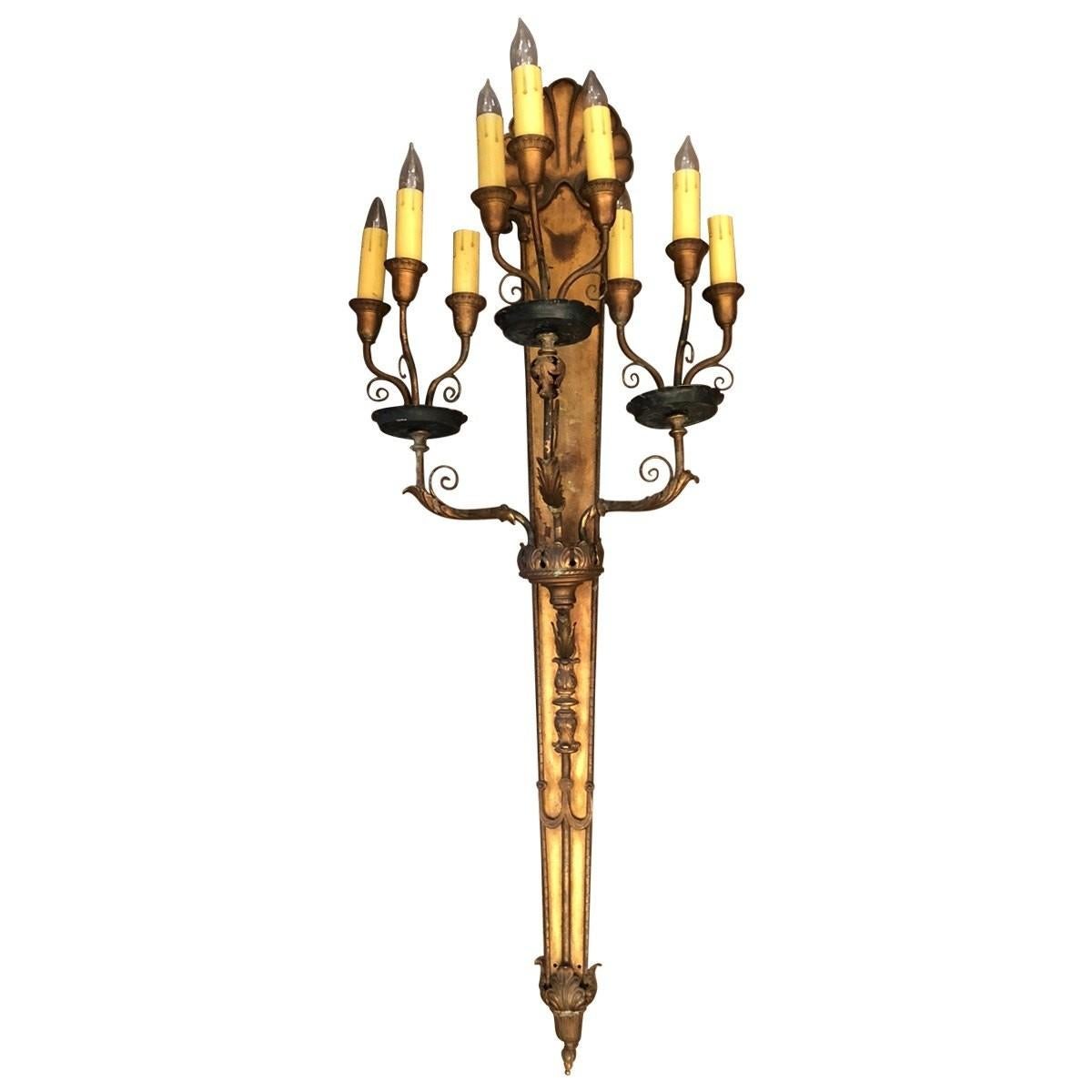 Pair of Lavish and ornate, wall sconces .This stunning pair of nine light Spanish style sconces features three clustered arms embellished with leaves and scrolls. Handmade in the early 20th century, these eye-catching candelabras bring instant