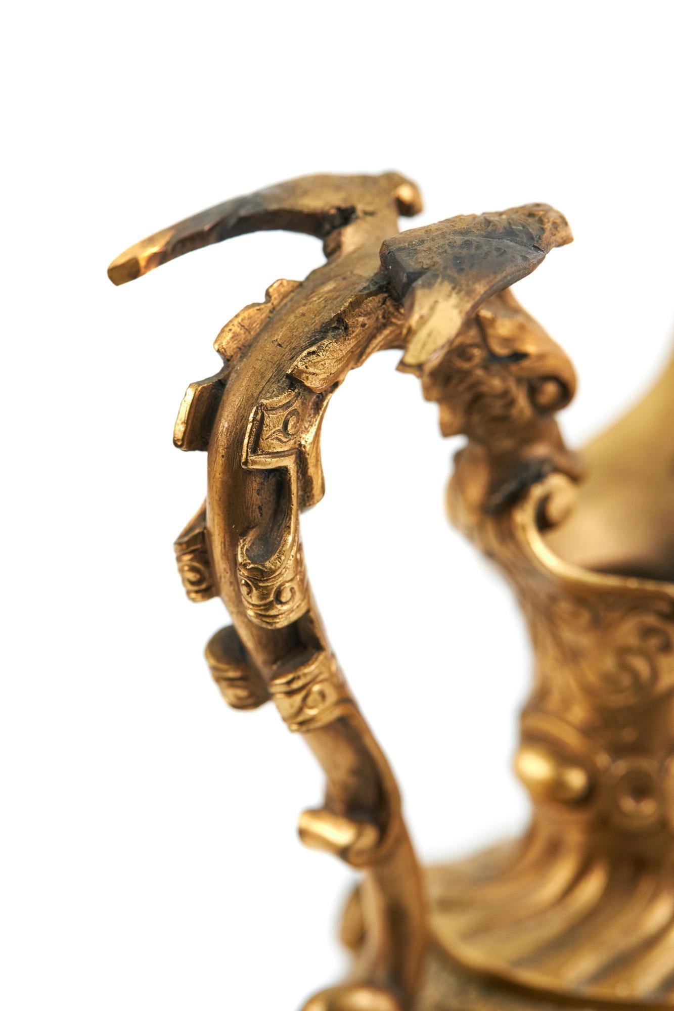 Coppia di spremiagrumi vittoriani ornati in bronzo dorato con manici di draghi volanti di qualità, vaso ornato di forma decorata con foglie d'acanto e disegno fogliare sollevato su basi circolari caricate a gradini.