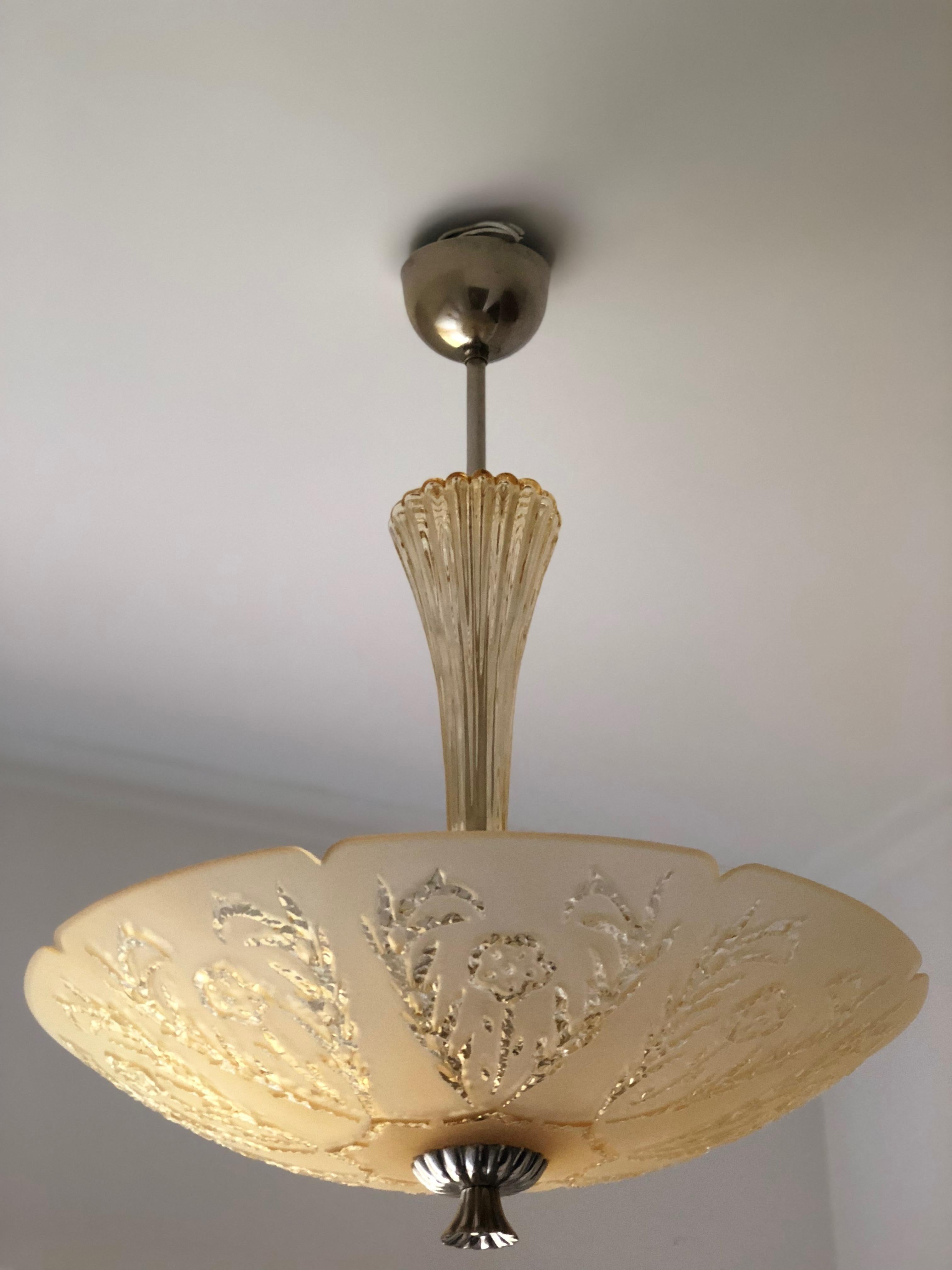 A pair of Orrefors Art Deco hanging fixture with etched shade. Beautiful peach color. Design by Fritz Kurz for the Swedish Glassmaker Orrefors. Great condition. A couple of nicks are found on the inside of the hole where the stem and nickel knob is