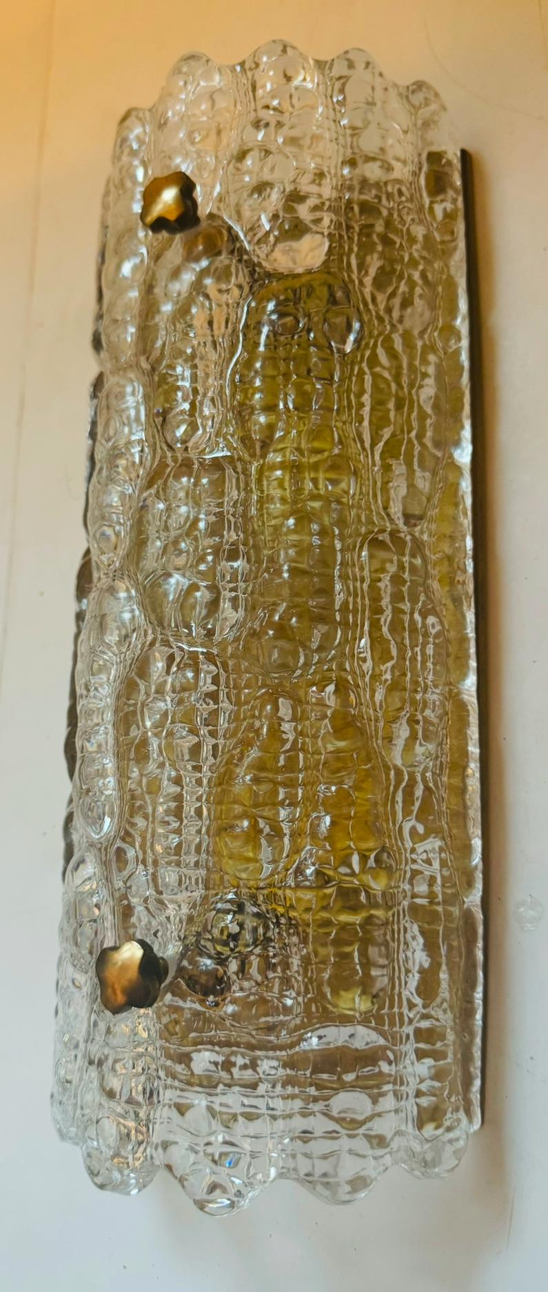 Una lussuosa coppia di lampade da parete svedesi in cristallo trasparente degli anni '50 con paralumi in vetro spesso, fissaggi in ottone invecchiato e accessori decorativi di Carl Fagerlund per Orrefors. Ricablata. Presa a candelabro.